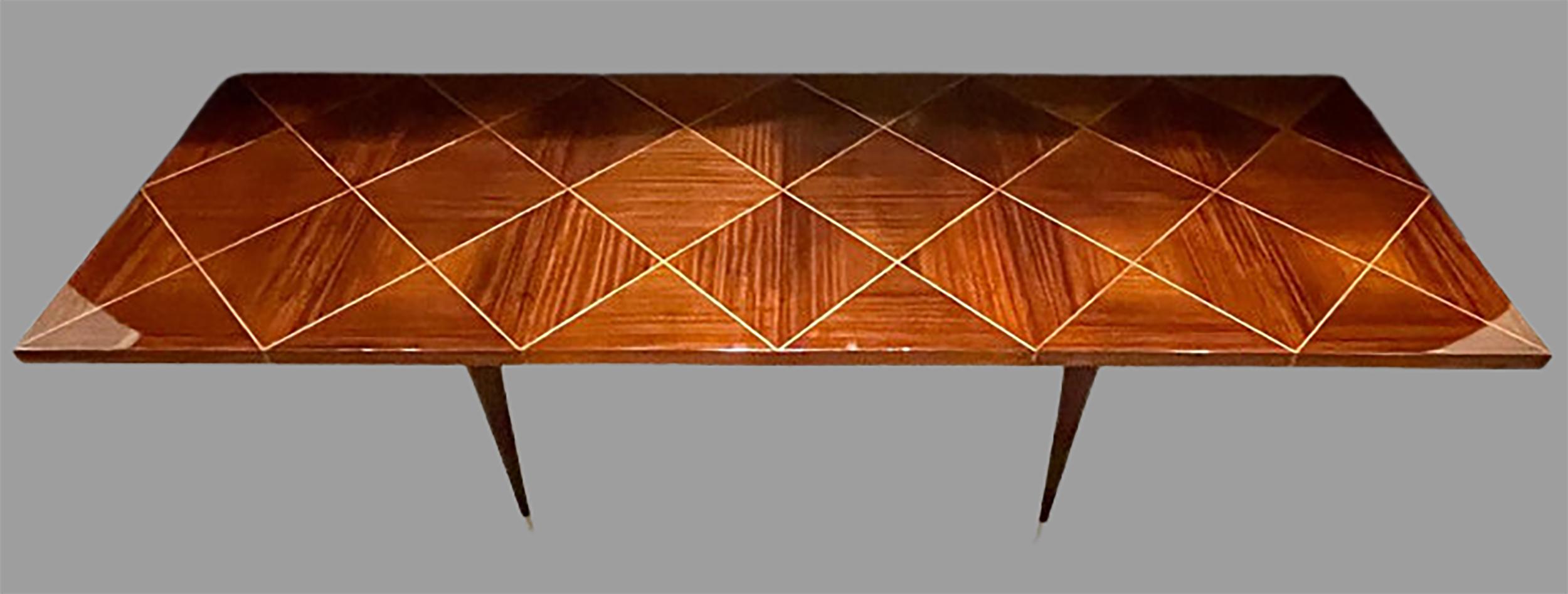 A Tommi Parzinger Originals Dining Table Fully Refinished with Two Leaves that measure 17.25 inches each. The sleek tapering reeded legs supporting a think sturdy table top of mahogany design with line inlays. The top finely done over to a mirror