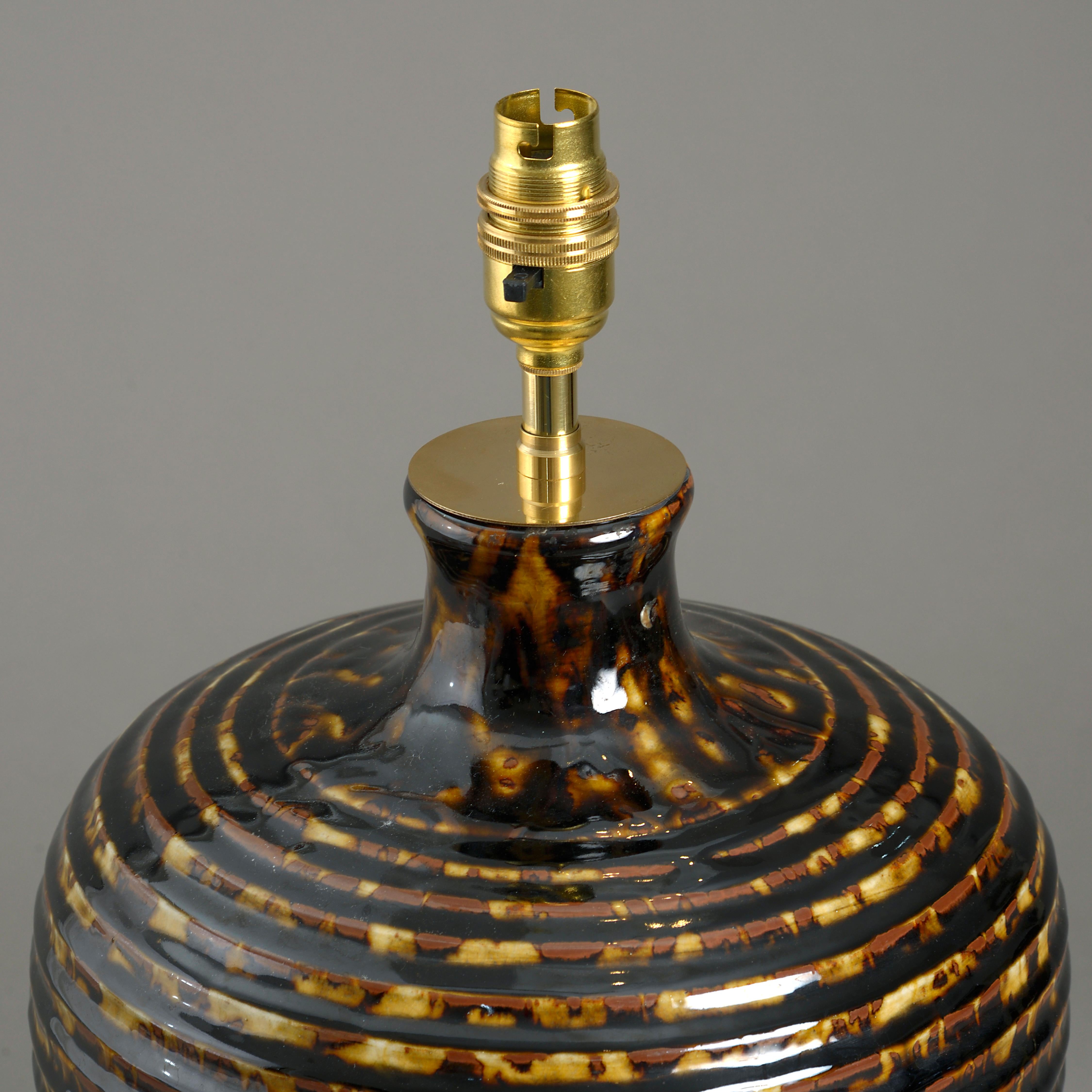 A tortoiseshell glazed vase, the body of ribbed tapering form. Now mounted as a table lamp.

Dimensions refer to vase, excluding electrical elements. Shade not included.