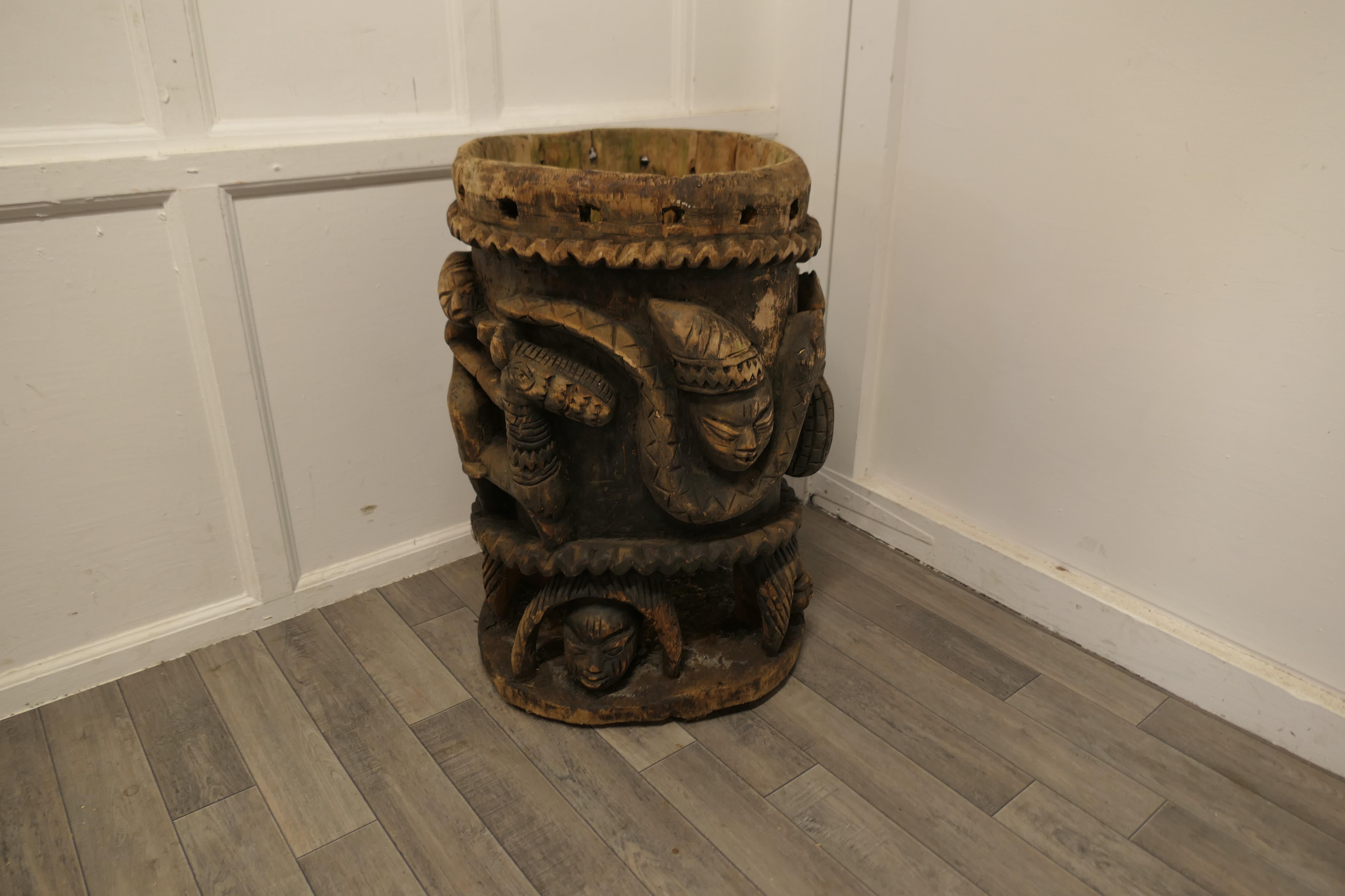 A Traditional African Carved Wooden Hunting Drum 

A substantially carved Wooden Drum, the drum has been hewn out of a single trunk, it shows Primitive huntsmen, animals and tools for working the land 
The drum skin is no longer present but the