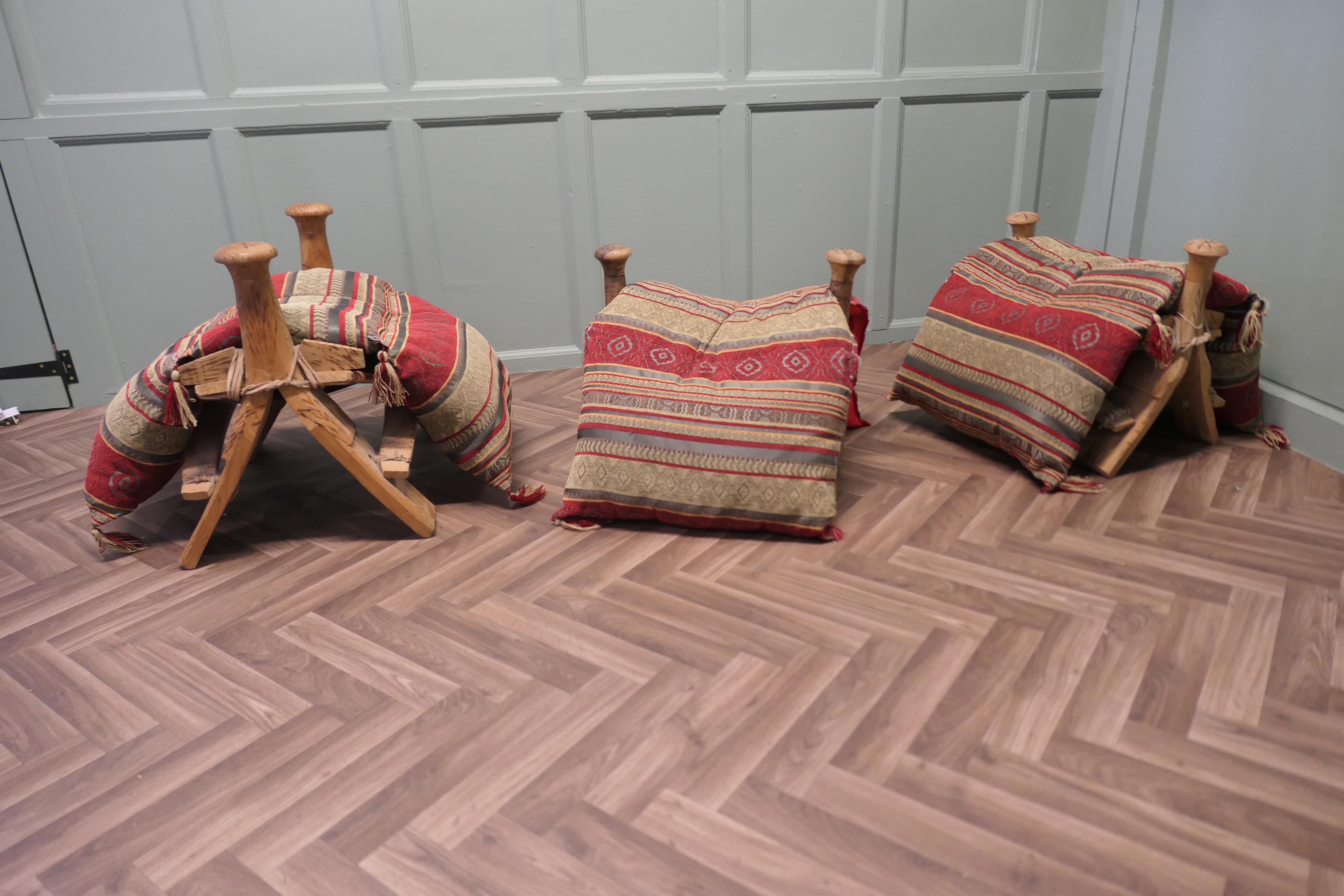 Una sella/sgabello di cammello tradizionale

Una tradizionale sella da cammello costruita con diversi pezzi di legno d'ulivo intagliato, legati insieme con strisce di pelle per formare uno sgabello con supporti distanziati e pomi rotondi a ciascuna