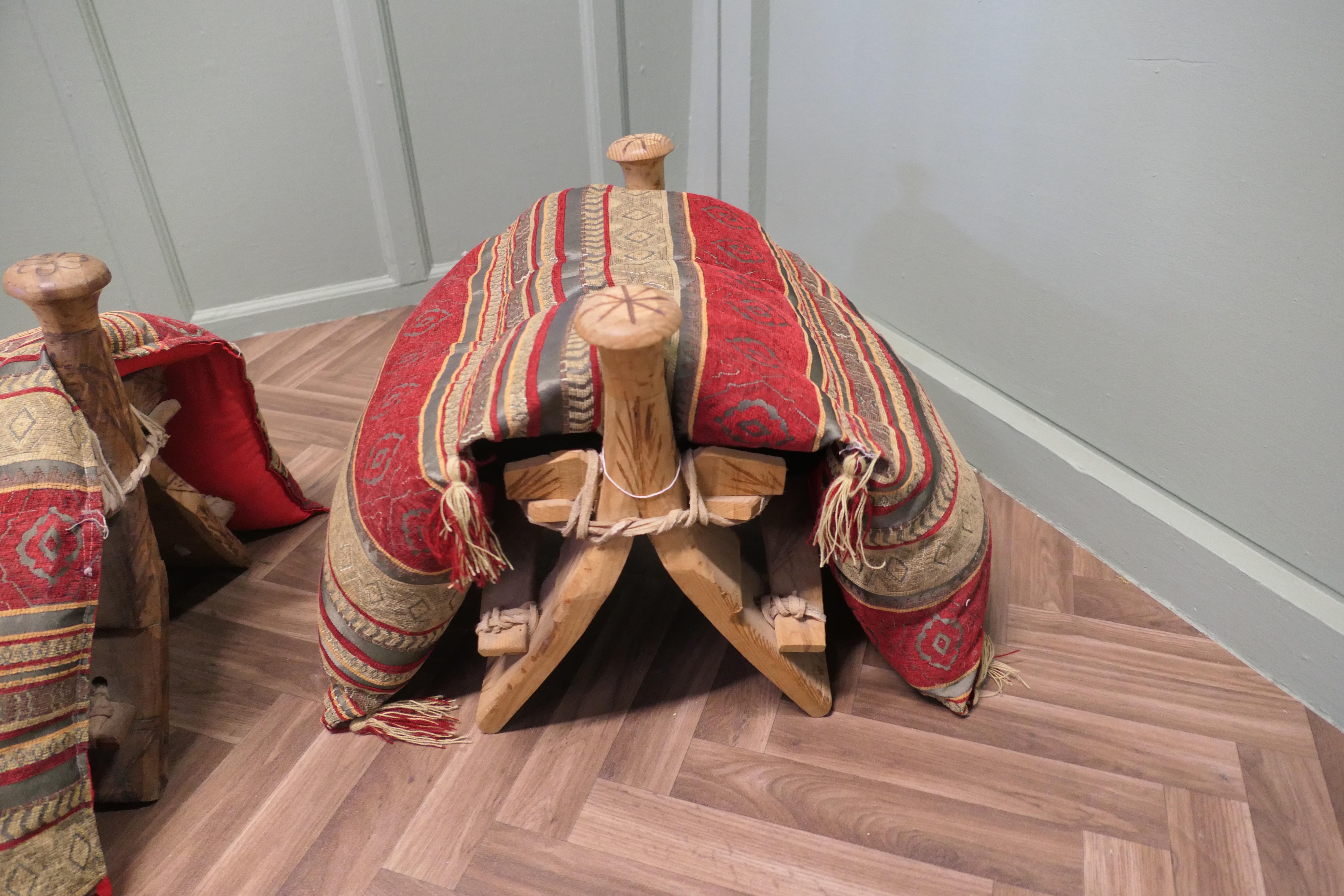 A Traditional Camel Saddle / Stool

A Traditional Camel Saddle constructed from several pieces of scratch carved olive wood, tied together with strips of hide to form a saddle stool with splayed supports and round pommels at each end, the saddle
