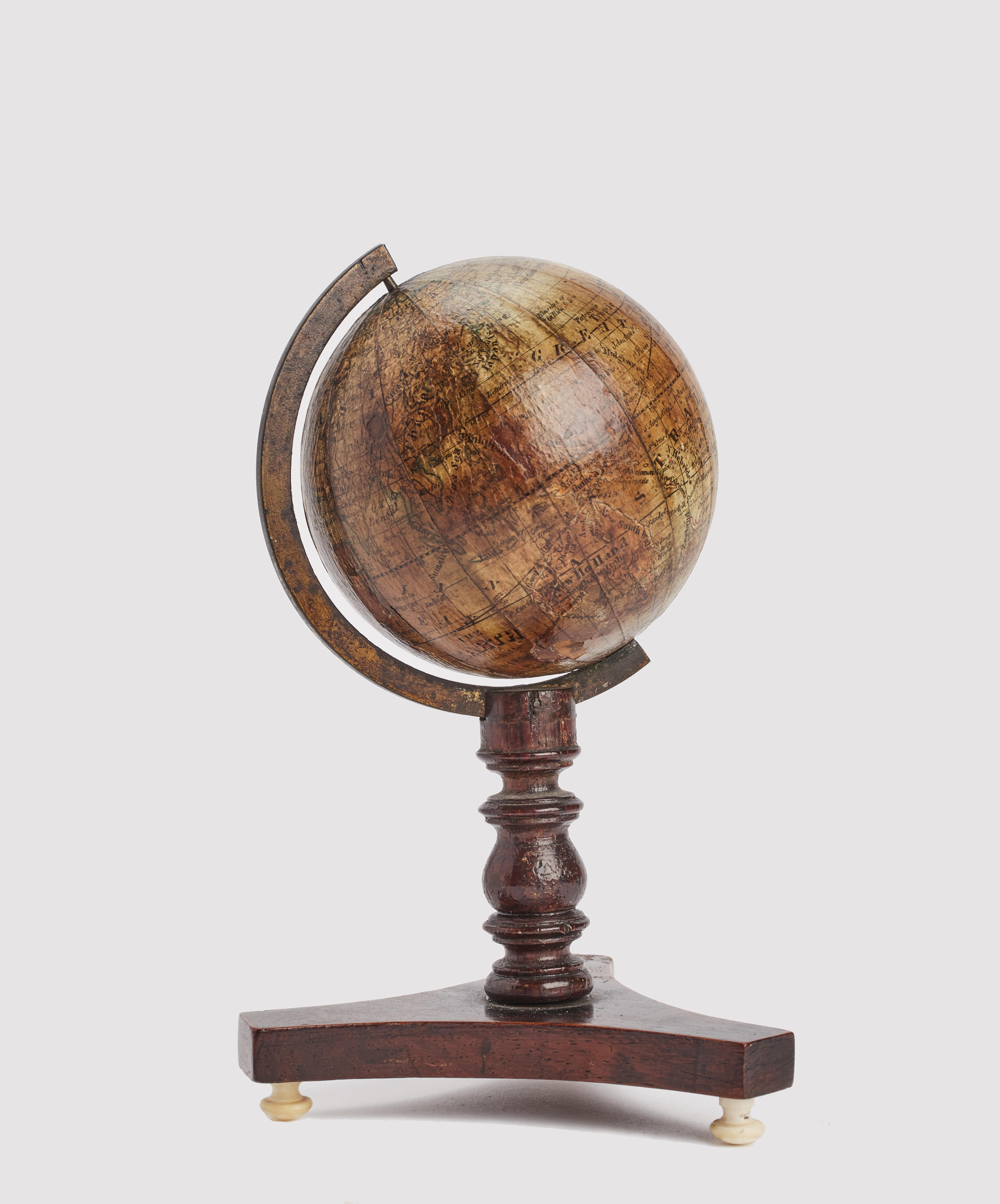 On a tripod base with ivory peduncles, a leg with a wavy profile rises. The brass half meridian is connected to it, which at its ends supports the axis of the small globe. The base is made of dark brown mahogany wood. The globe is made of