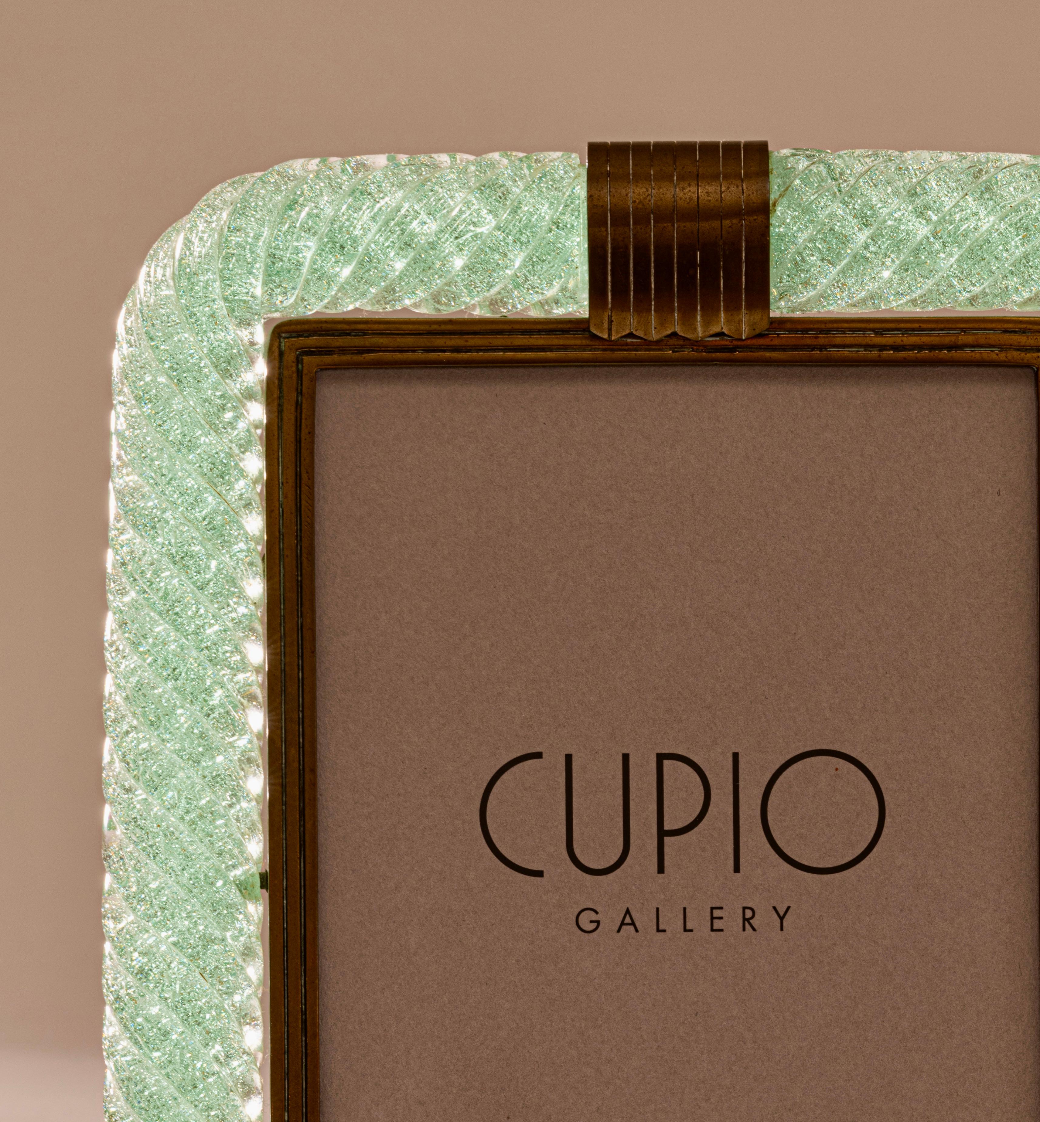 A rare ‘a treccia' green pulegoso glass picture frame designed by architect and designer Carlo Scarpa and produced by the famous Italian glass house, Venini, c.1938. This 'braided' glass photo frame has a light, luminous quality and is a truly
