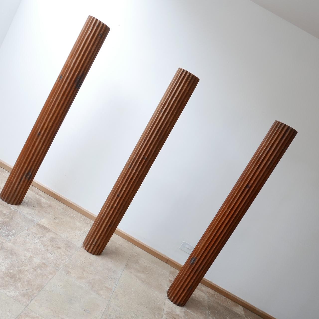 Three wooden columns, with a metal central strut running through. 

Possibly of industrial use. 

They are a matching set of three but possibly could be cut to different sizes creating more than three and making a great retail, artwork or home