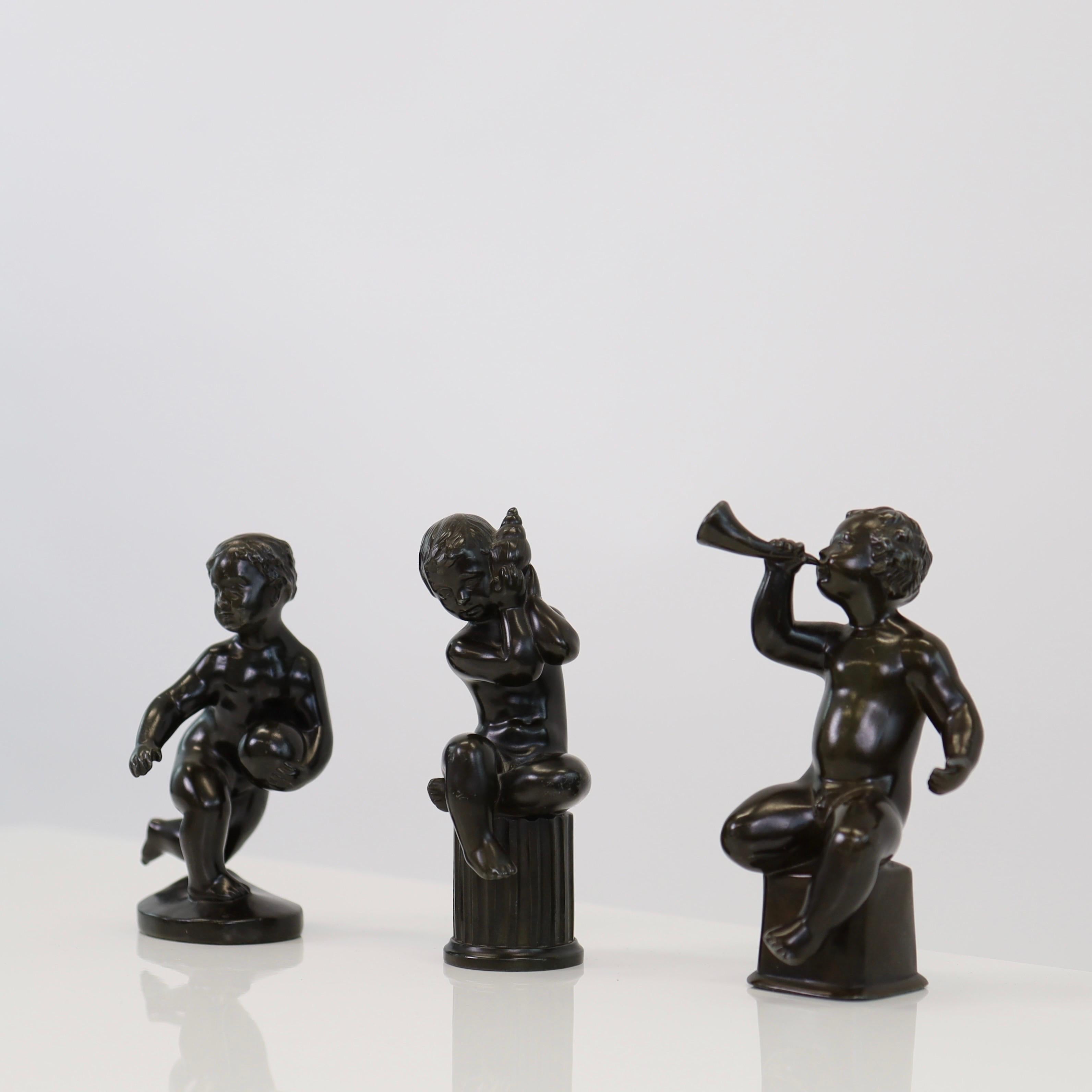 A trio 'Boy Band' in good vintage condition designed by Just Andersen in 1930s.

* A trio (3) of small metal sculptures of a boys with a ball, a horn and a seashell
* Designer: Just Andersen
* Style: D1900, D2170 and D2355
* Condition: Very good