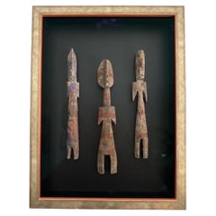 Un trio de figurines traditionnelles en bois sculpté de la culture Ewe