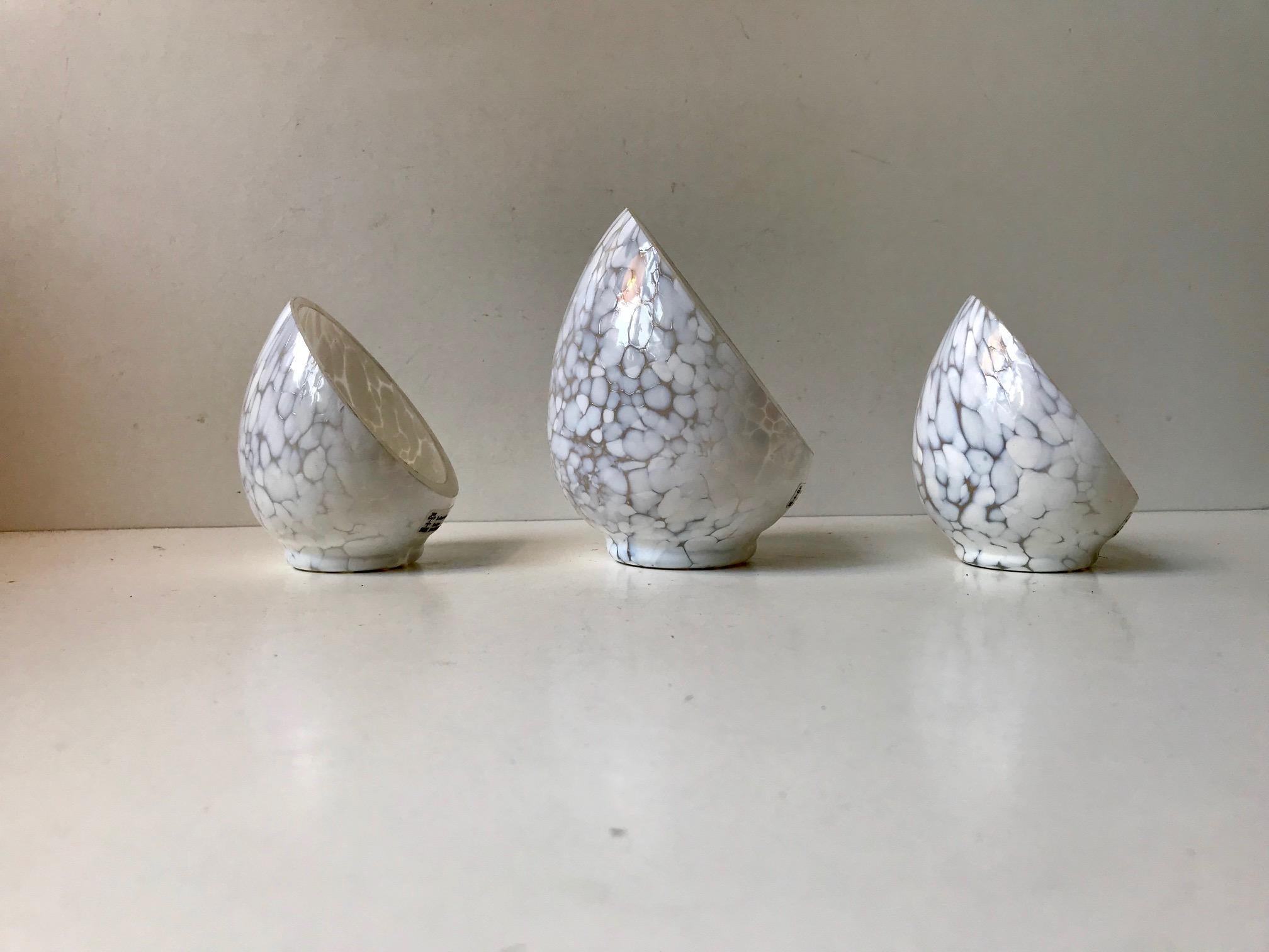A set of candleholders for tea or bloc candles. Composed of clear and white blister glass, blown and shaped by hand. Designed by Ingegerd Råman and manufactured by Skruf in Sweden during the 1980s-1990s. Please note that one of them is slightly
