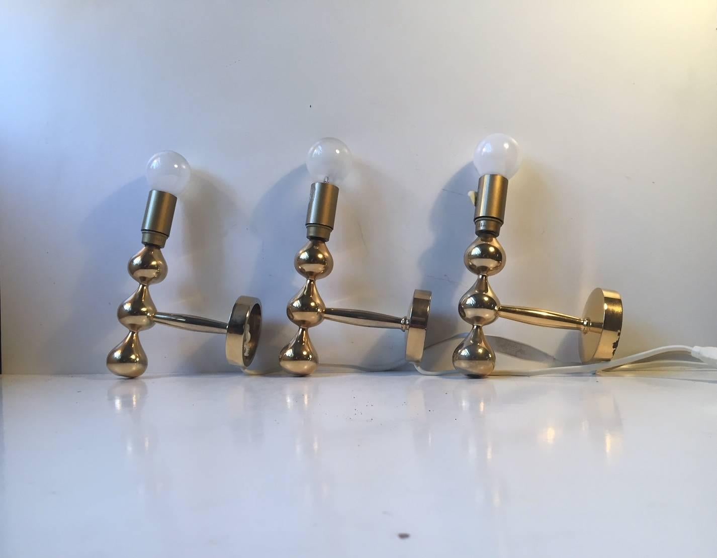 Sculptural tear drop shaped set of 24-carat gold plated sconces designed by Hugo Asmussen for Asmussen in Denmark, circa 1960. Very heavy made stock in a superb quality. The price is for the set of three.