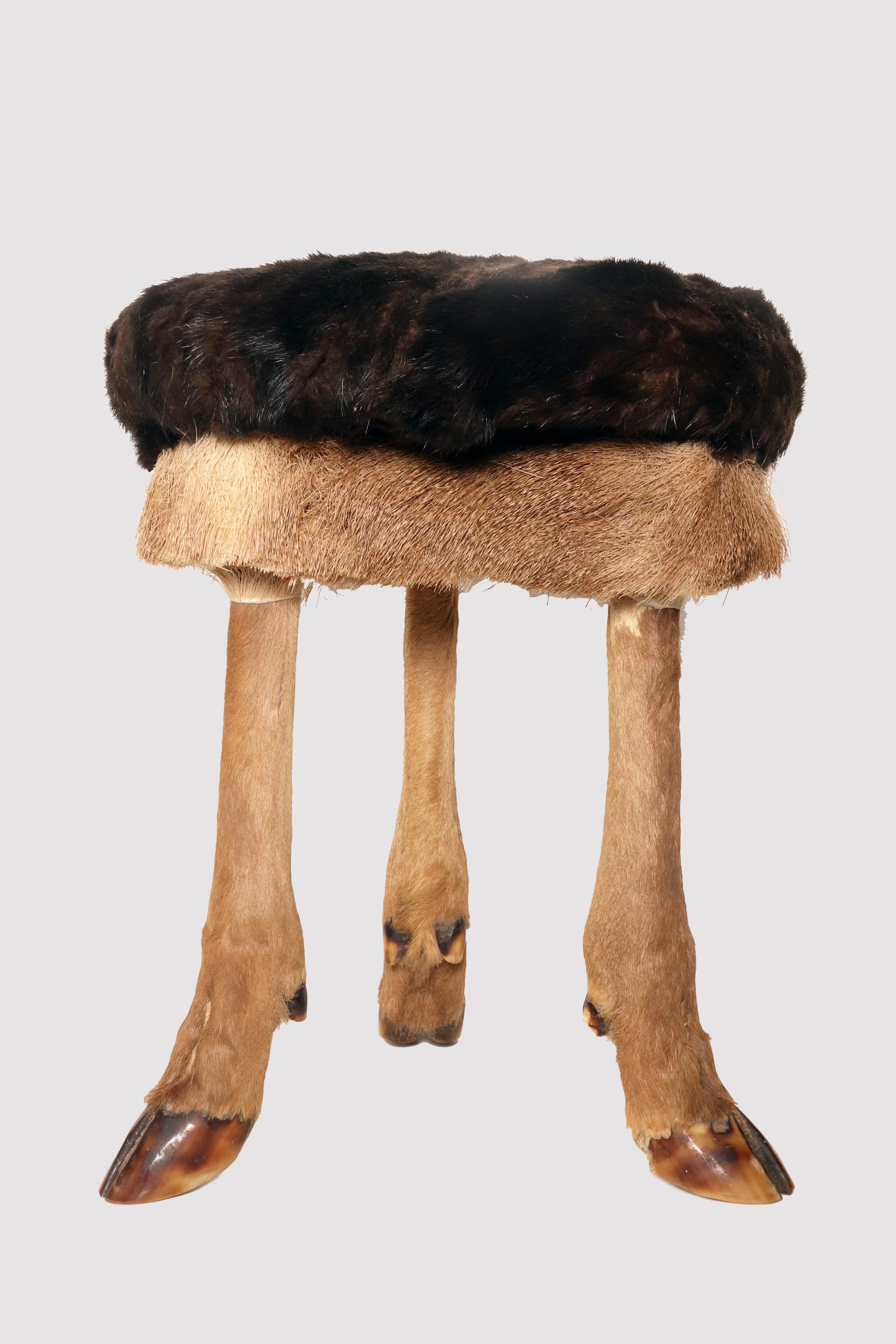 Tabouret tripode, provenant d'un chalet autrichien, fabriqué à partir de trois pattes de cerf. Le siège de forme ronde, en bois fruitier, est recouvert de fourrure de cerf. Autriche vers 1880.