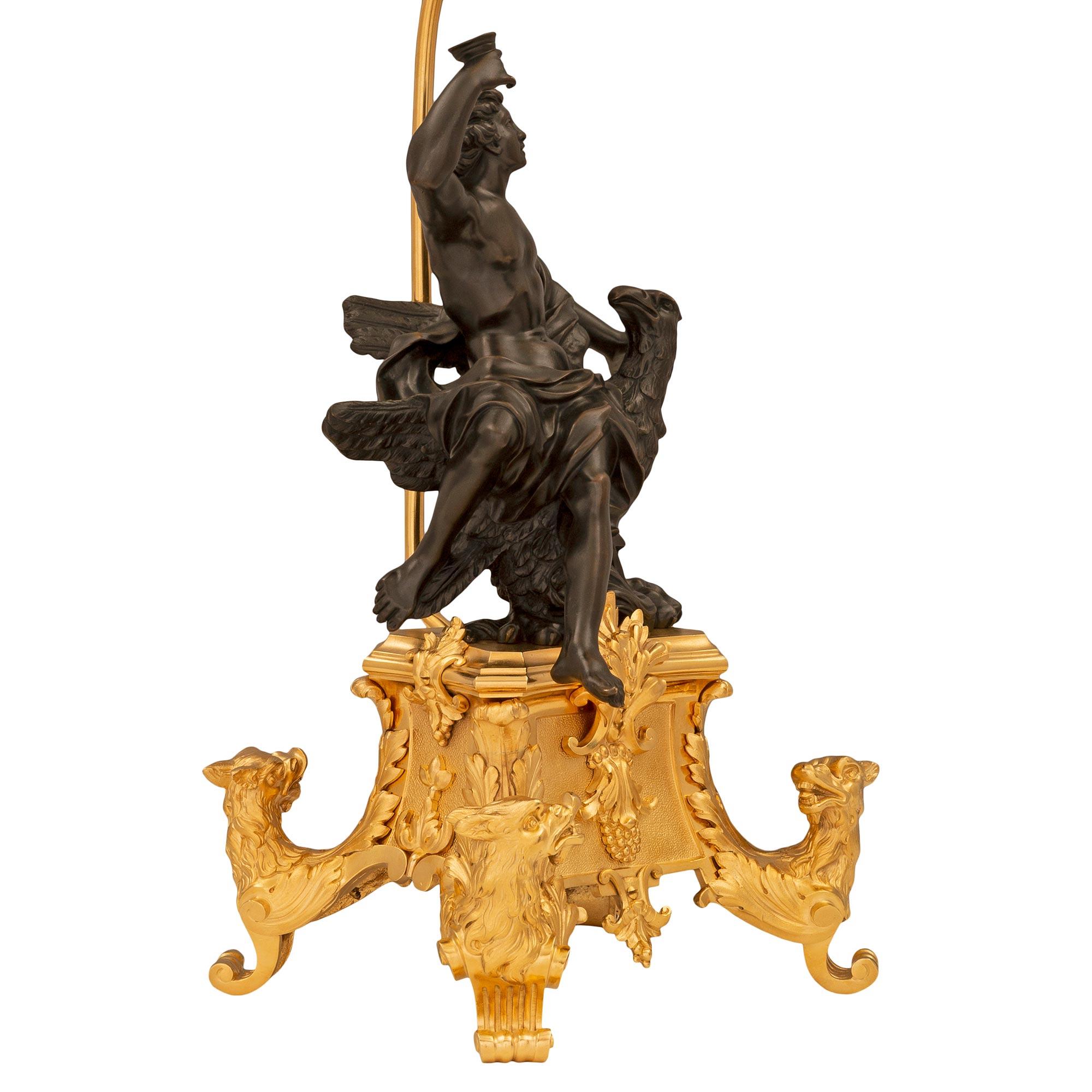 A striking and very high quality true pair of French 19th century Louis XIV st. ormolu and patinated bronze lamps. Each lamp is raised by an exceptional and most decorative curved ormolu base with superb central foliate and berried reserves and