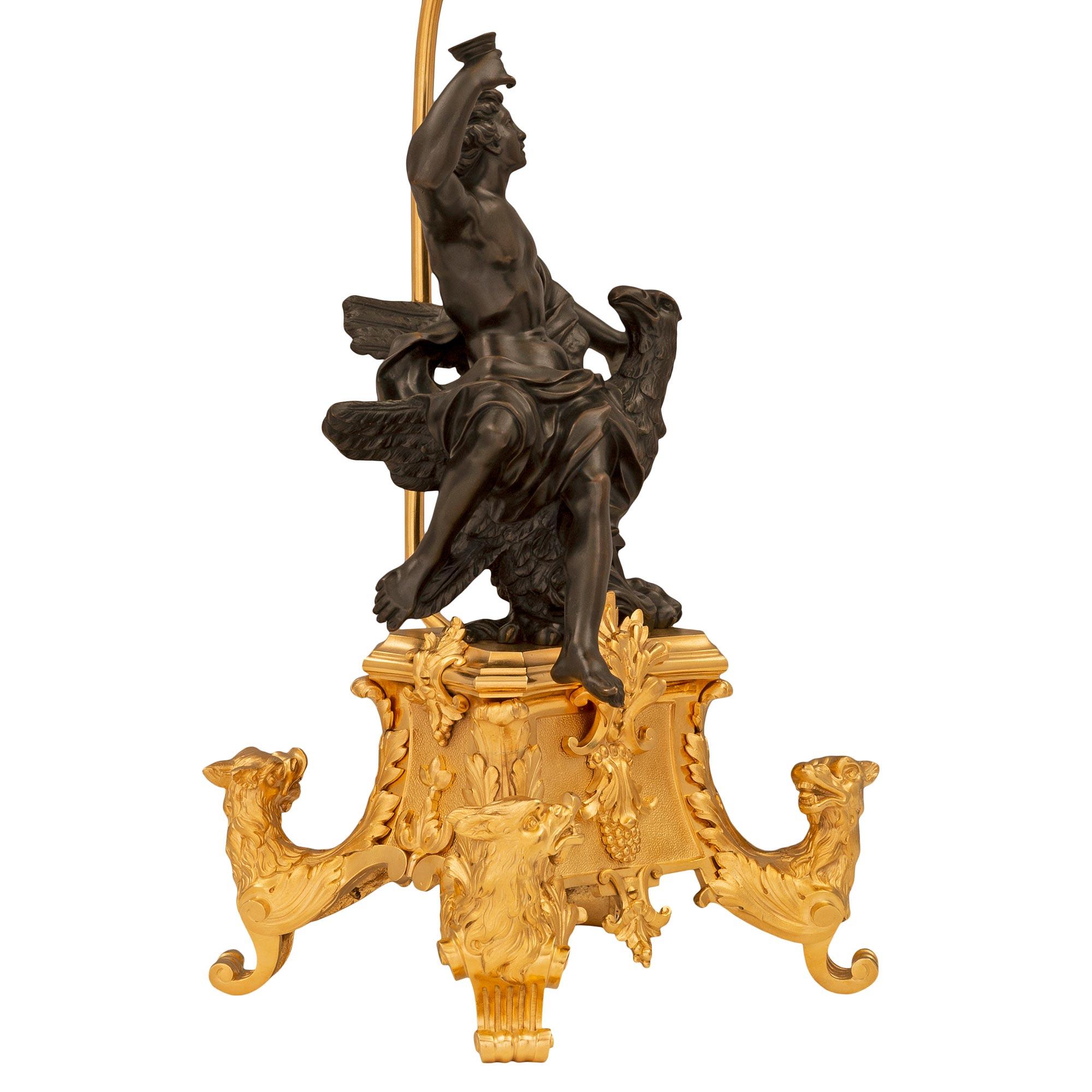 Una coppia di lampade in bronzo patinato e ormolu del XIX secolo, di grande effetto e di altissima qualità. Ogni lampada è sollevata da un'eccezionale e decorativa base in ormolu curvo con superbe riserve centrali a fogliame e bacche e piedi a