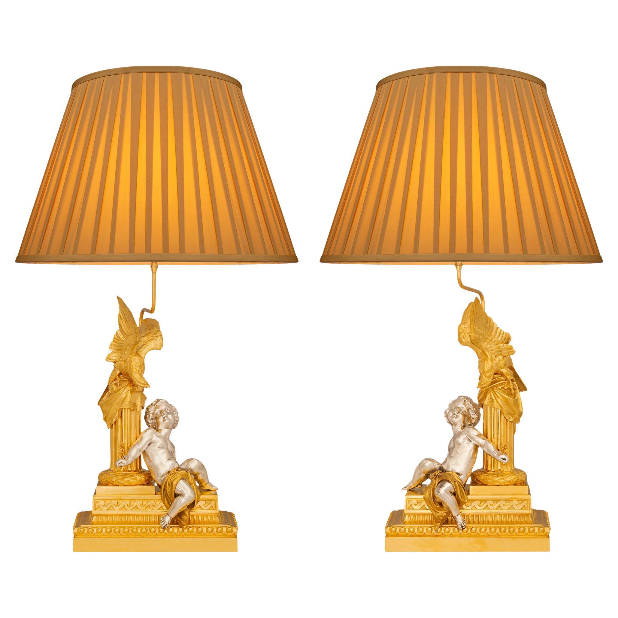 A stunning and highly decorative true pair of French 19th century Louis XVI st. Ormolu and Silvered Bronze 
lamps. Each lamp depicting Prometheus's punishment by Zeus is raised on a rectangular and stepped Ormolu base that is tastefully decorated