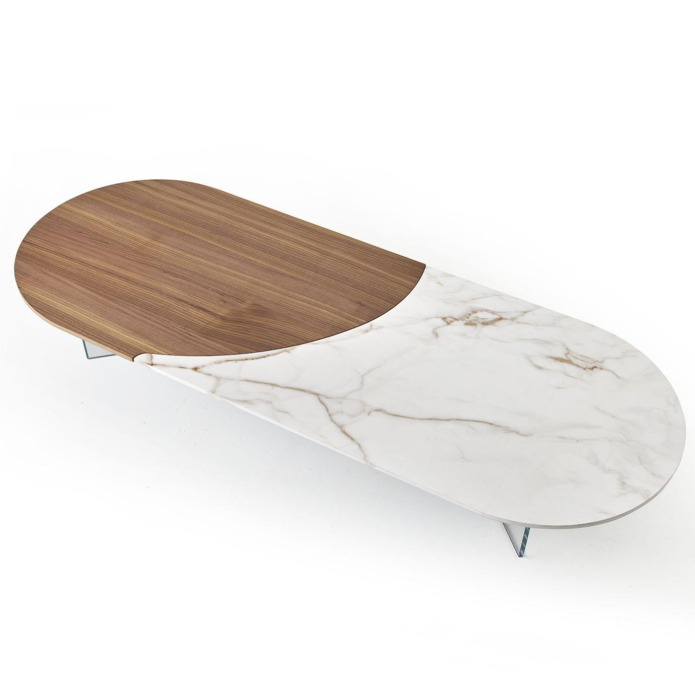 Bold, captivating, and daring. This coffee table captures the essence of less is more. The table's oval silhouette is comprised of 2 materials, solid Canaletto walnut and white Calacatta ceramic slab, arranged to seamlessly fit along an undulating