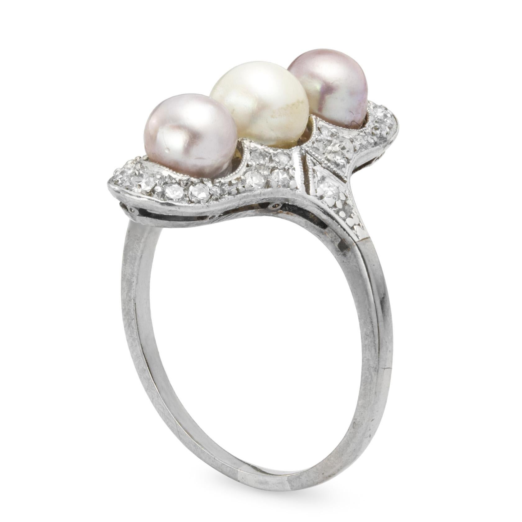 A turn of the century pearl and diamond tablet ring, set vertically with three round pearls of different colours to the centre of an openwork old brilliant-cut diamond-set surround, circa 1900, head measuring 2.2x1.2cm, gross weight 5.1 grams.