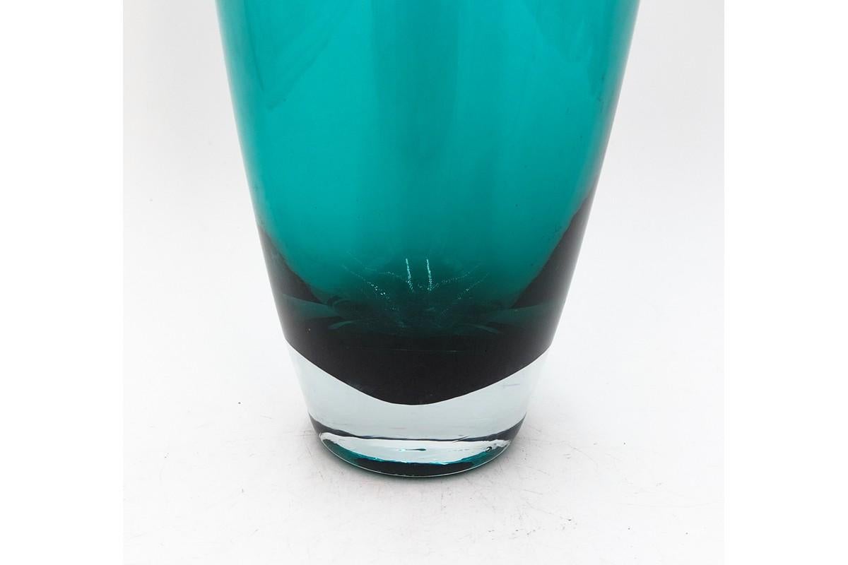A tall turquoise glass vase

Made in Poland in the 1970s

Very good condition, no damage

Measures: height 45, diameter 10cm.