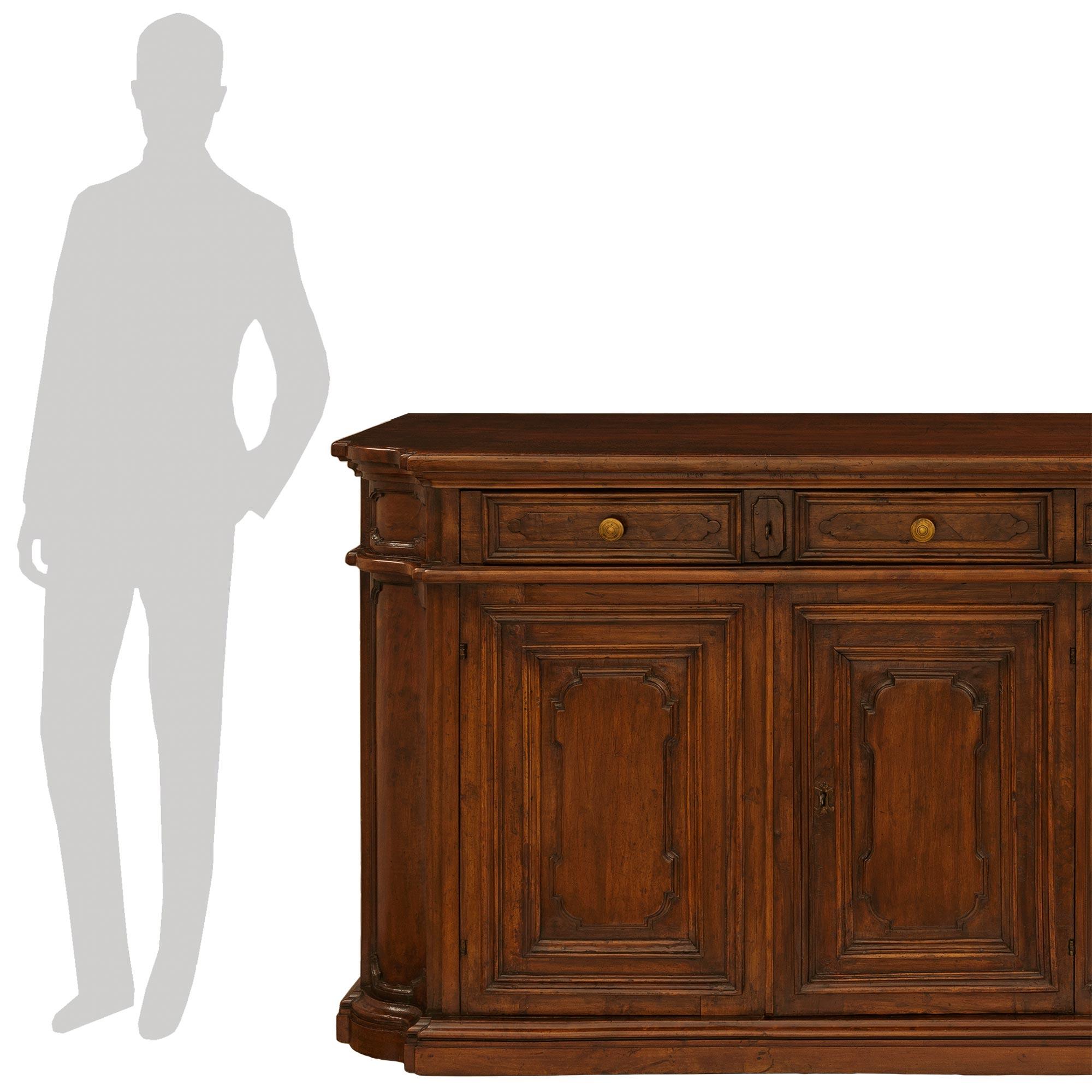 Ein beeindruckendes und großzügiges toskanisches Barockbuffet aus Nussbaum und Eisen aus dem 18. Dieses hübsche Buffet wird von einem gesprenkelten Sockel mit abgerundeten Ecken unter den vier rechteckigen Türen mit erhabenen und gesprenkelten