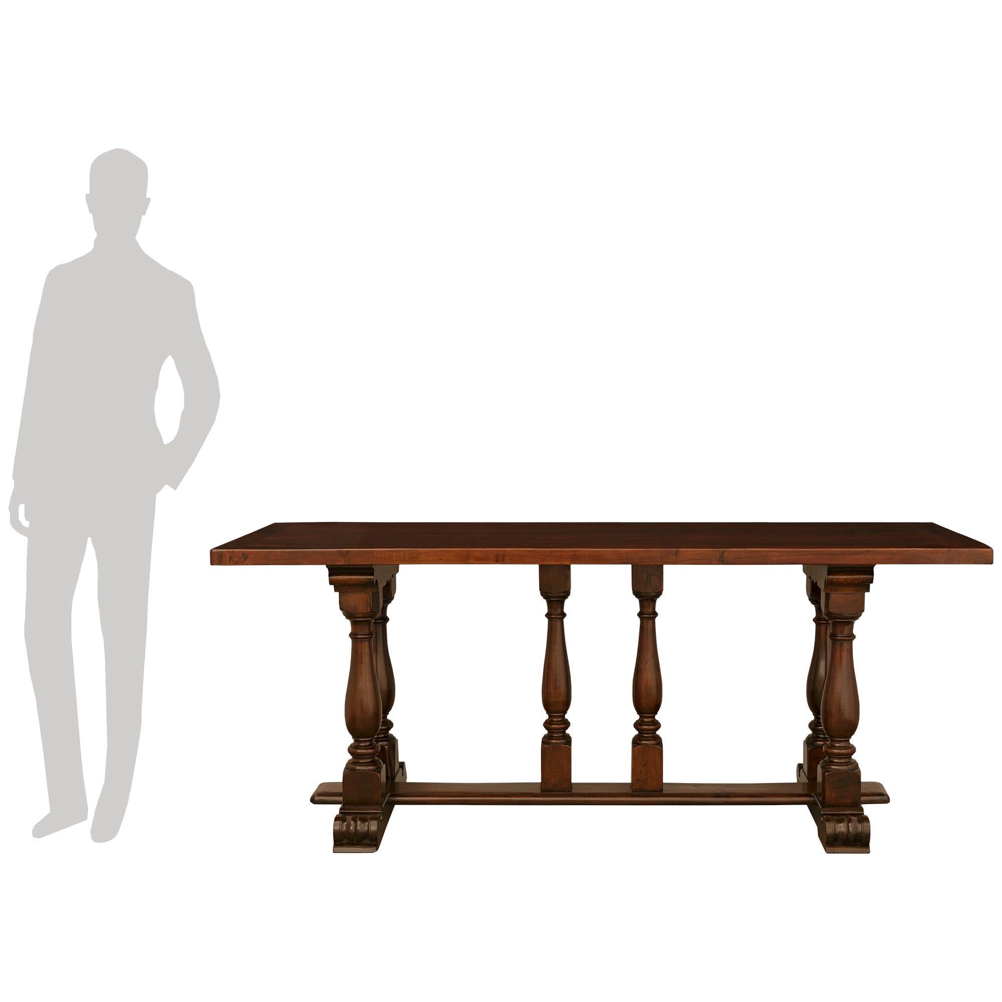 A handsome and most decorative Tuscan early 19th century Walnut trestle table. This wonderful rectangular table is raised on two wide plinths below scrolled feet, and joined by a flat Walnut stretcher. Above are six turned baluster shaped supports,