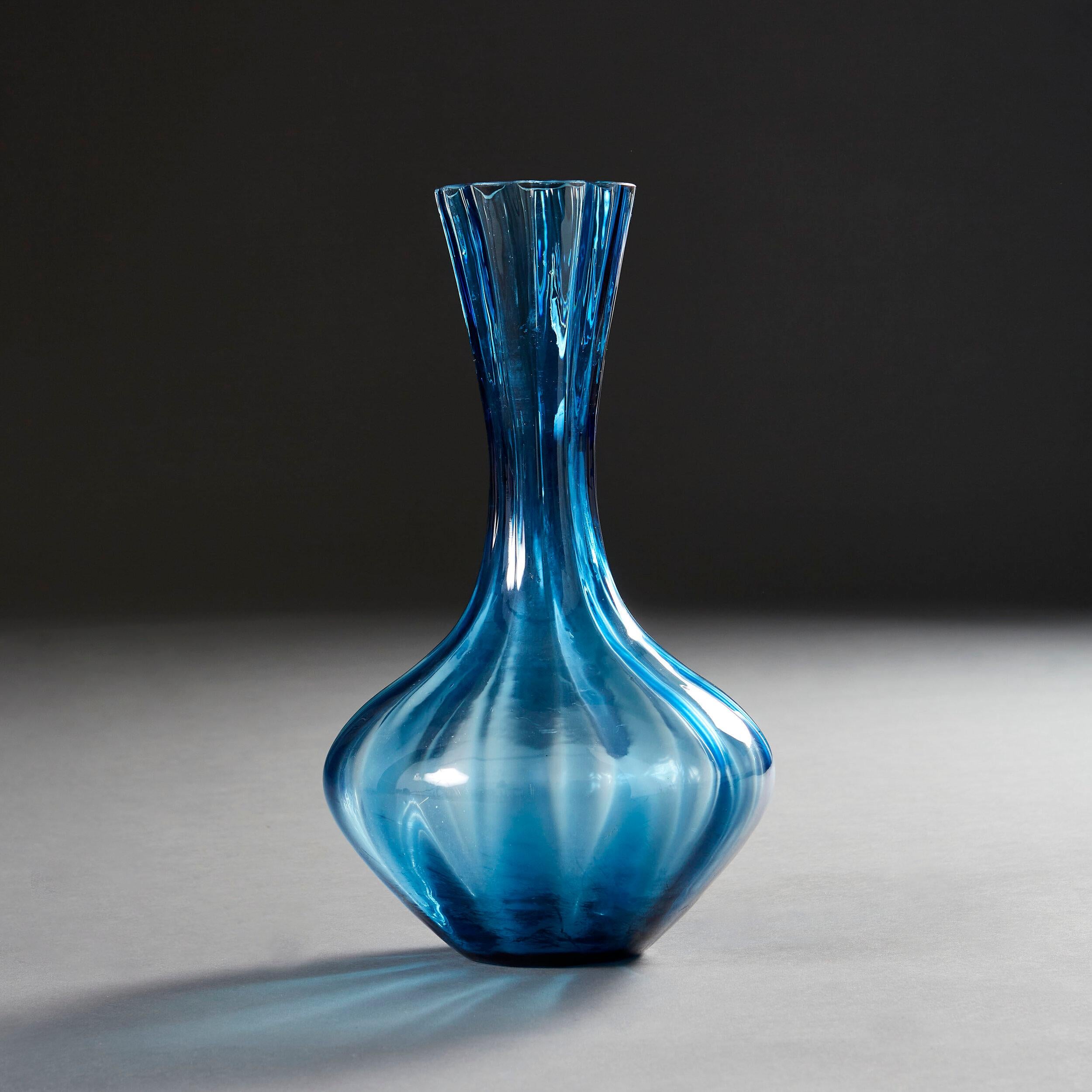 A mid-twentieth century blue glass vase with twisted stem, now as a lamp.

Please note that the lampshade is not included, and that the lamp is currently wired for the UK.