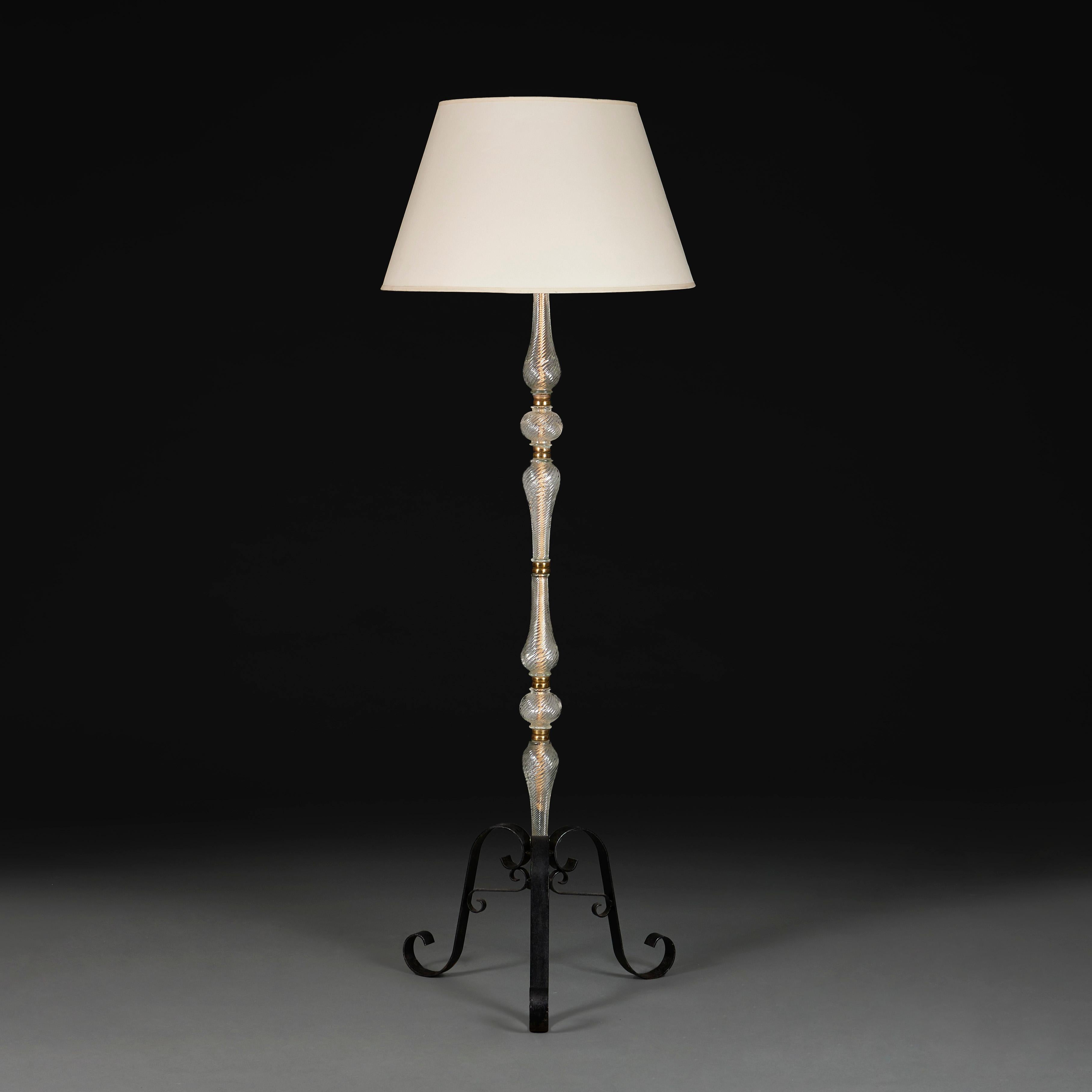 Italy, circa 1940

A mid twentieth century Murano glass standard lamp, with segmented twisted glass stem, the pieces all joined by brass rings, all supported on a wrought iron tripod base with scrolling feet.

Height of column 150.00cm

Width of