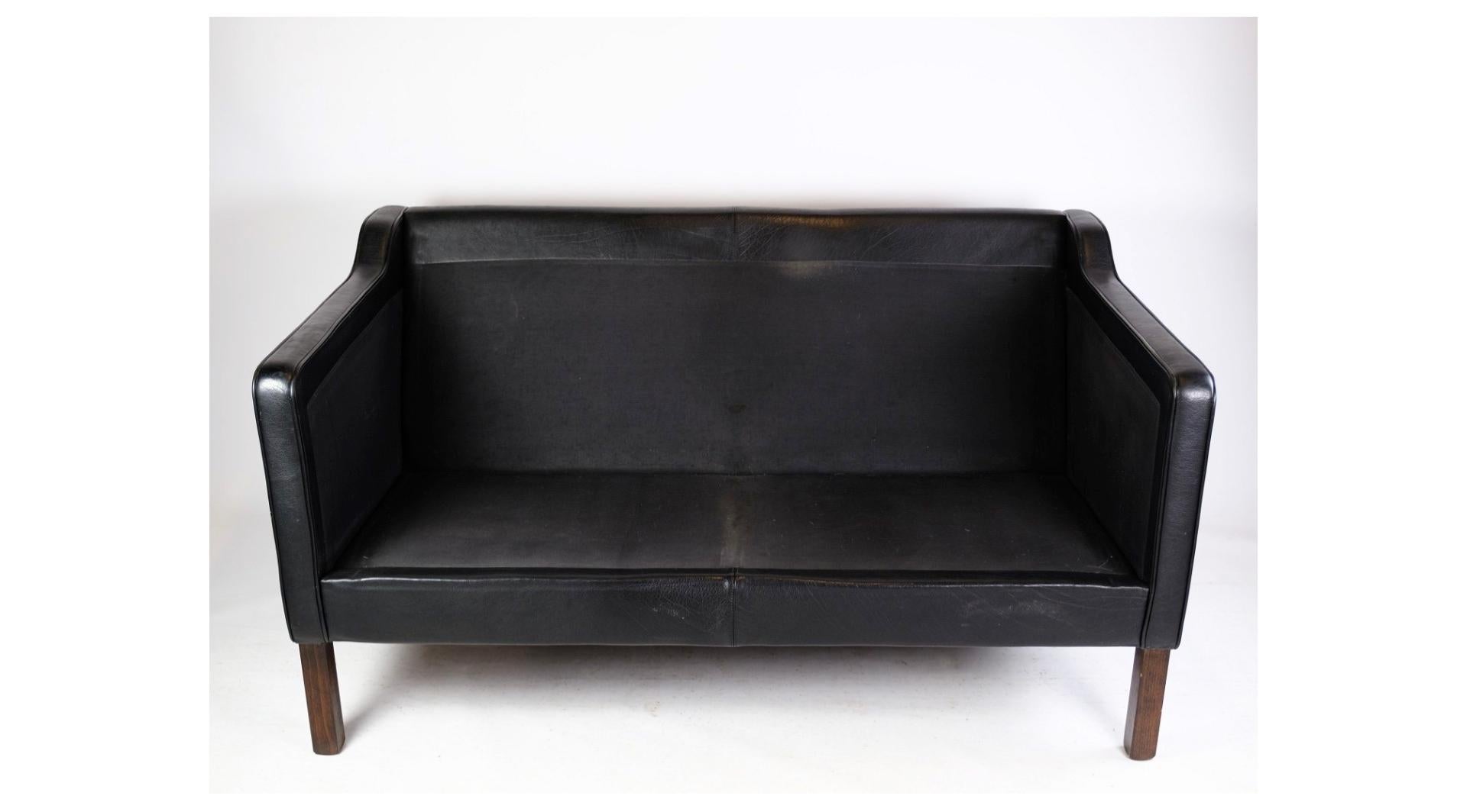 A two-seater sofa upholstered in black leather made by Stouby Møbelfabrik in the 1960s. The sofa stands with natural patina as well as loose cushions and armrests. A sofa of high quality and design.
Dimensions in cm: H: 75 W: 144 D: 66 SH: