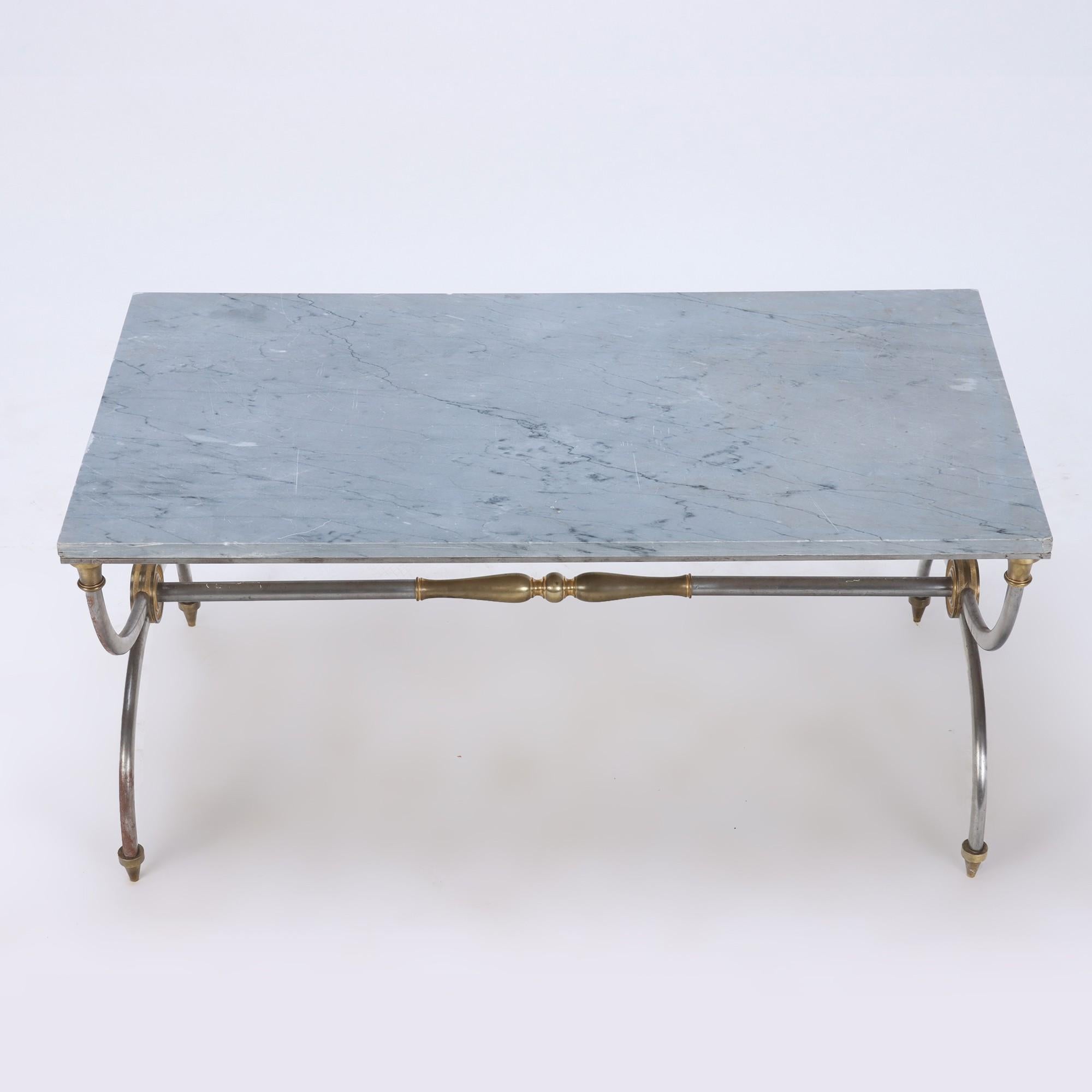 A two-tone bronze and steel coffee table in the French Empire style, Jansen, having a marble top with blue grey tint. Circa 1950.