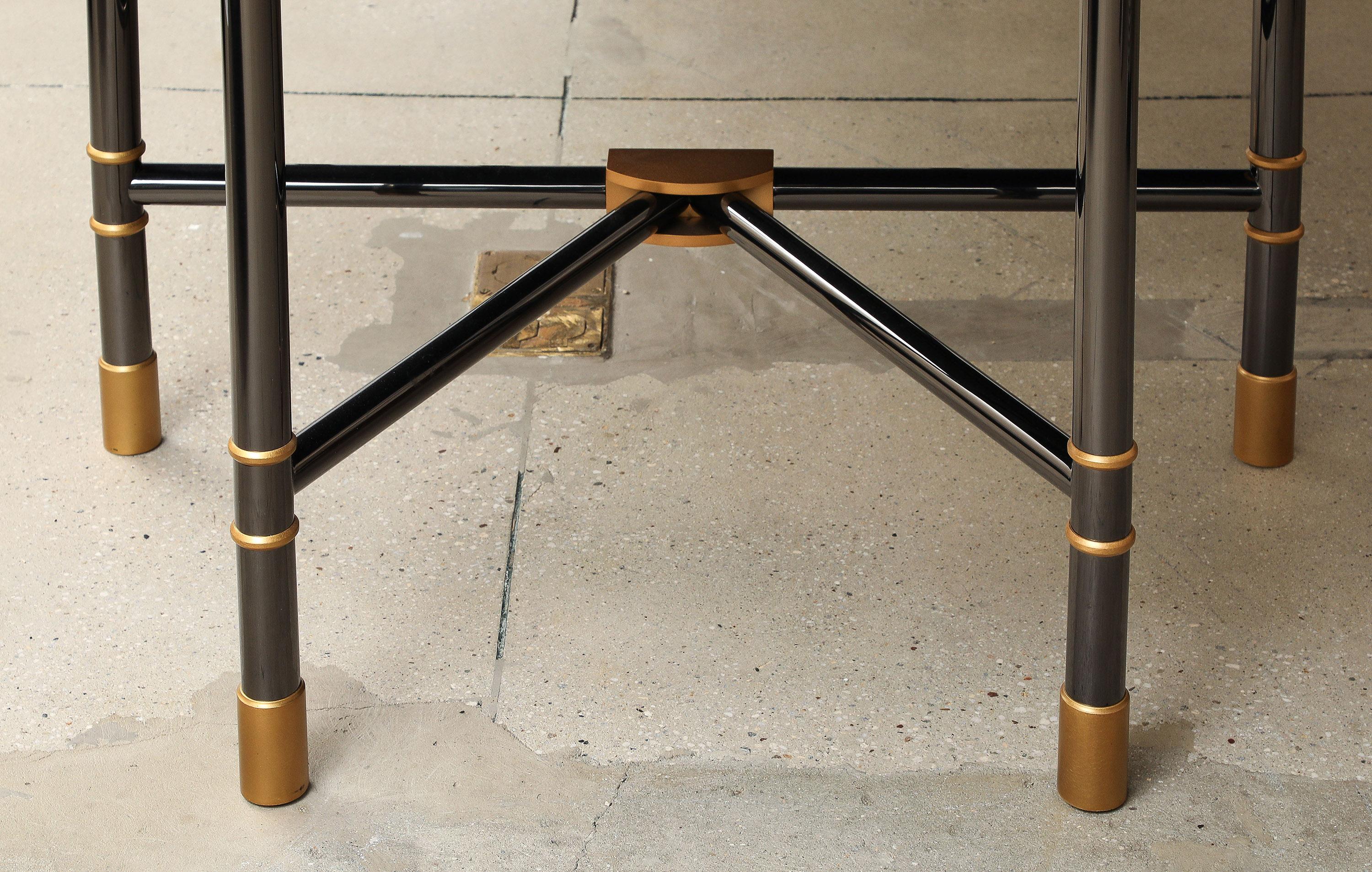 A Superb and Unique Bronze and Granite Dining Table. The custom bronze table having a doré bronze top with granite inserts over a steel frame. The whole resting on a patinated and doré bronze base. Signed with Karl Springer label.