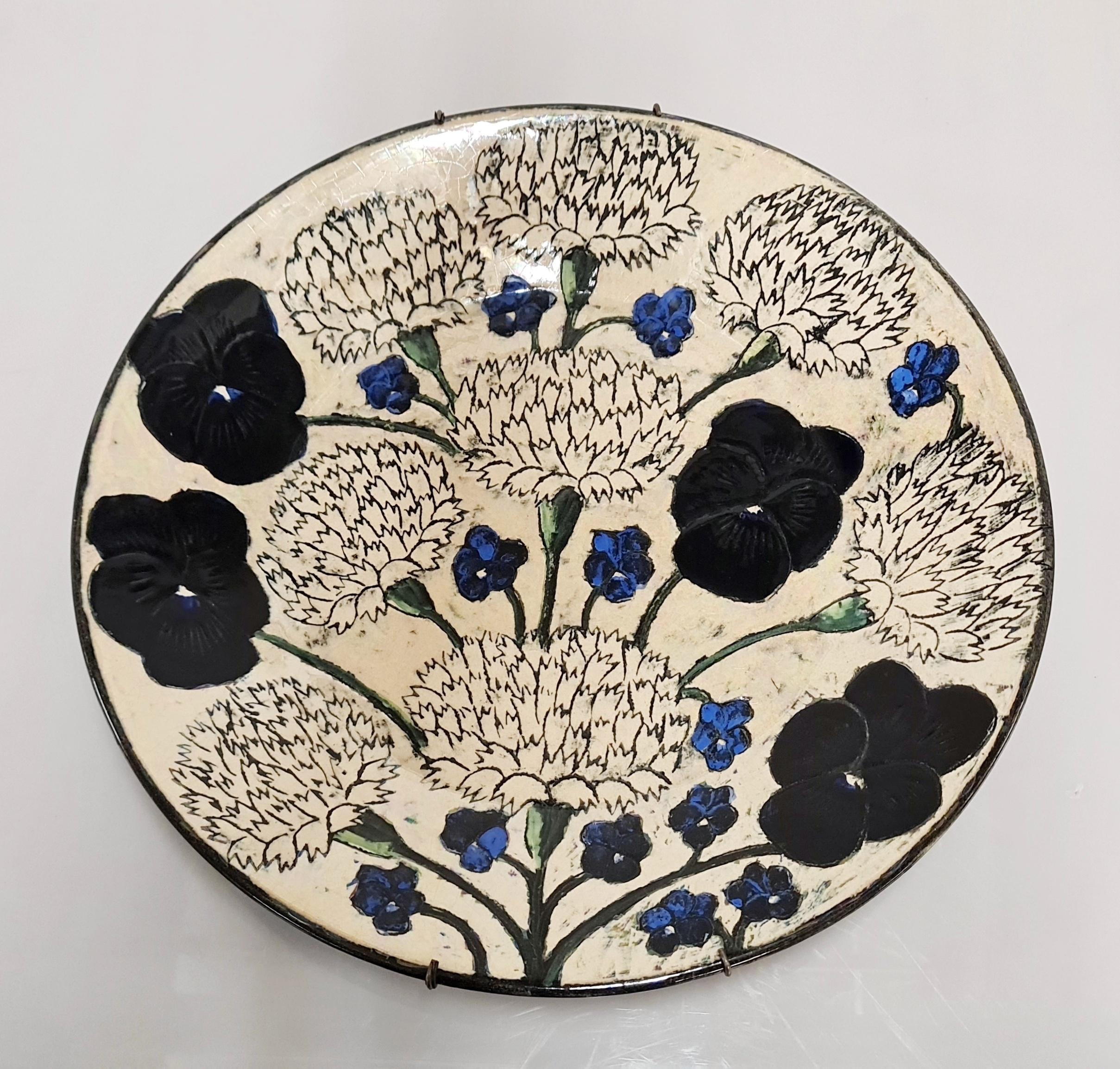 Un bellissimo piatto unico in ceramica disegnato da Birger Kaipianen per Arabia of Finland negli anni '70, decorato con diversi tipi di fiori. Questo pezzo è un buon esempio dell'abilità dell'artista nell'utilizzare i colori e i dettagli della