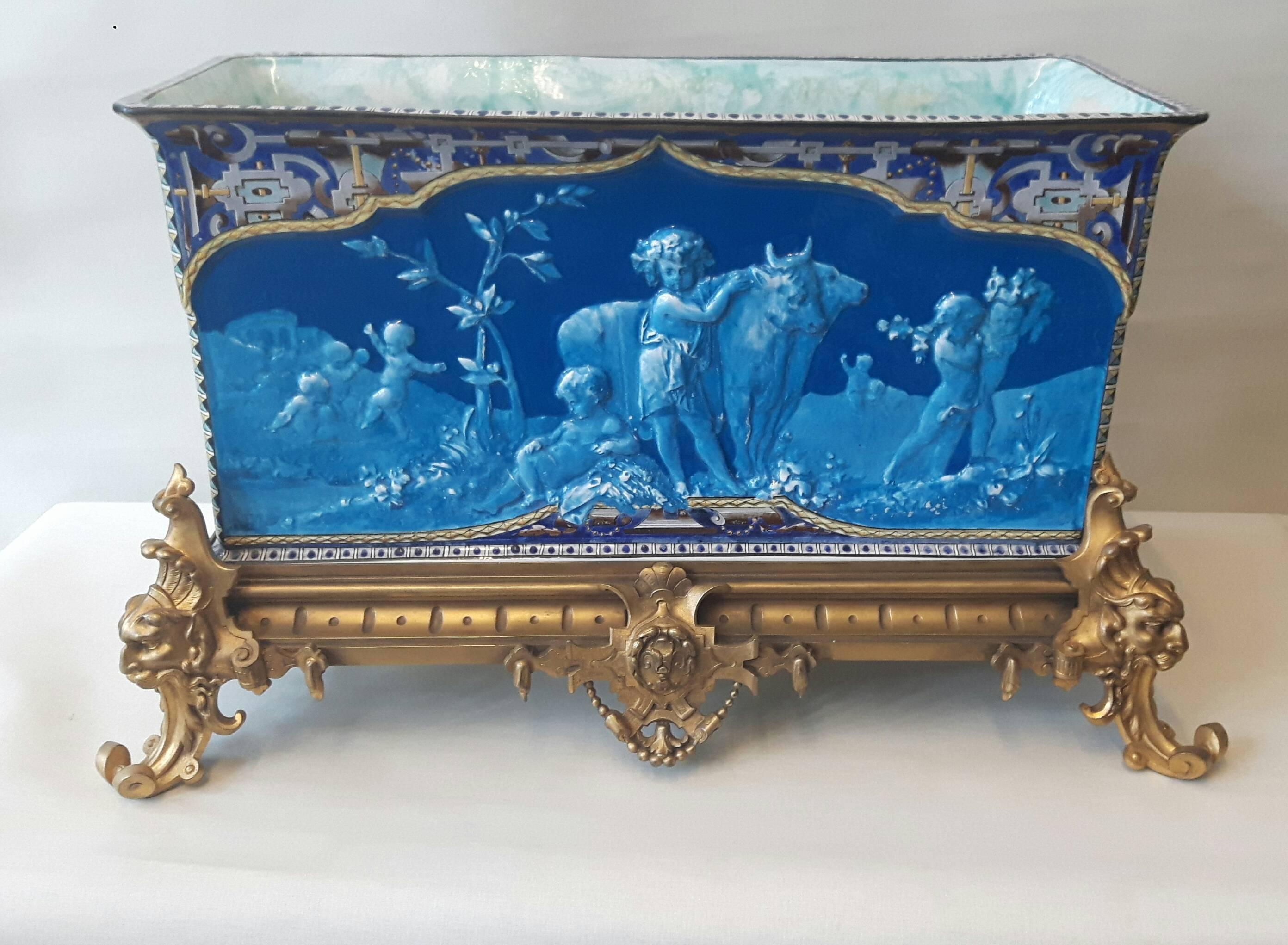 A very large ornate French jardinière Napoleon III period, painted in the 18th century style'' en grisalle'' with putti or cherubs re -enacting mythological scenes. The top part of the jardinière is hand-painted to resemble cloissone.
The base is