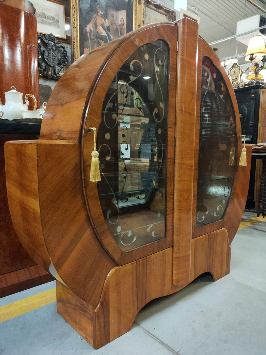 A unique and “one of a kind” piece, most likely made for an individual order, glass cabinet in Art Deco style.
Glass of doors, decorated with painted silver, mirror floral ornament.
A piece of furniture with a very interesting structure and shape,