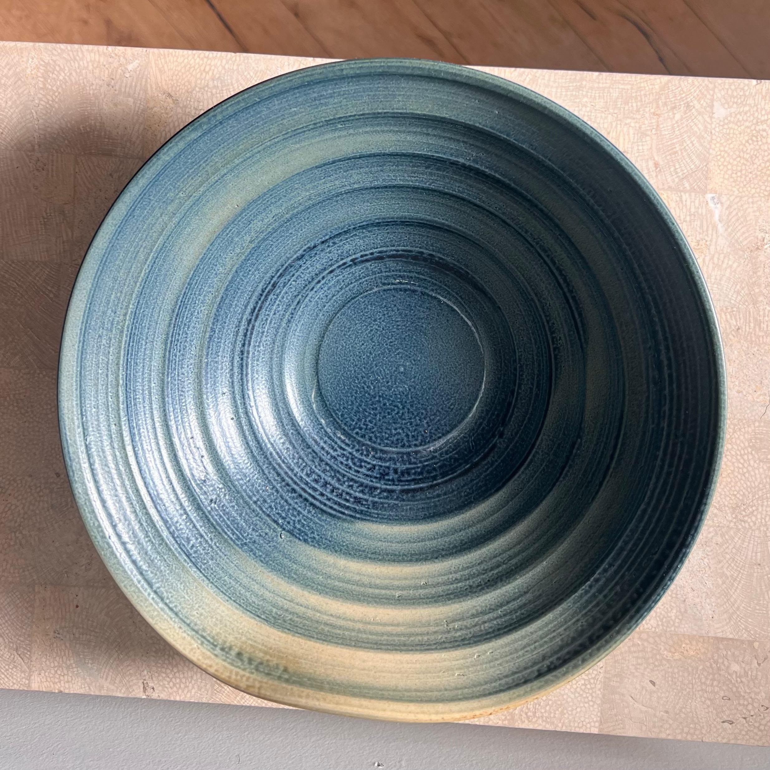Un'esclusiva ciotola da portata o da frutta in ceramica postmoderna di Studio A, caratterizzata da una struttura graduata, un labbro asimmetrico e un tema di colori ombré, probabilmente della fine del XX secolo. Nei toni del blu reale con un ombré
