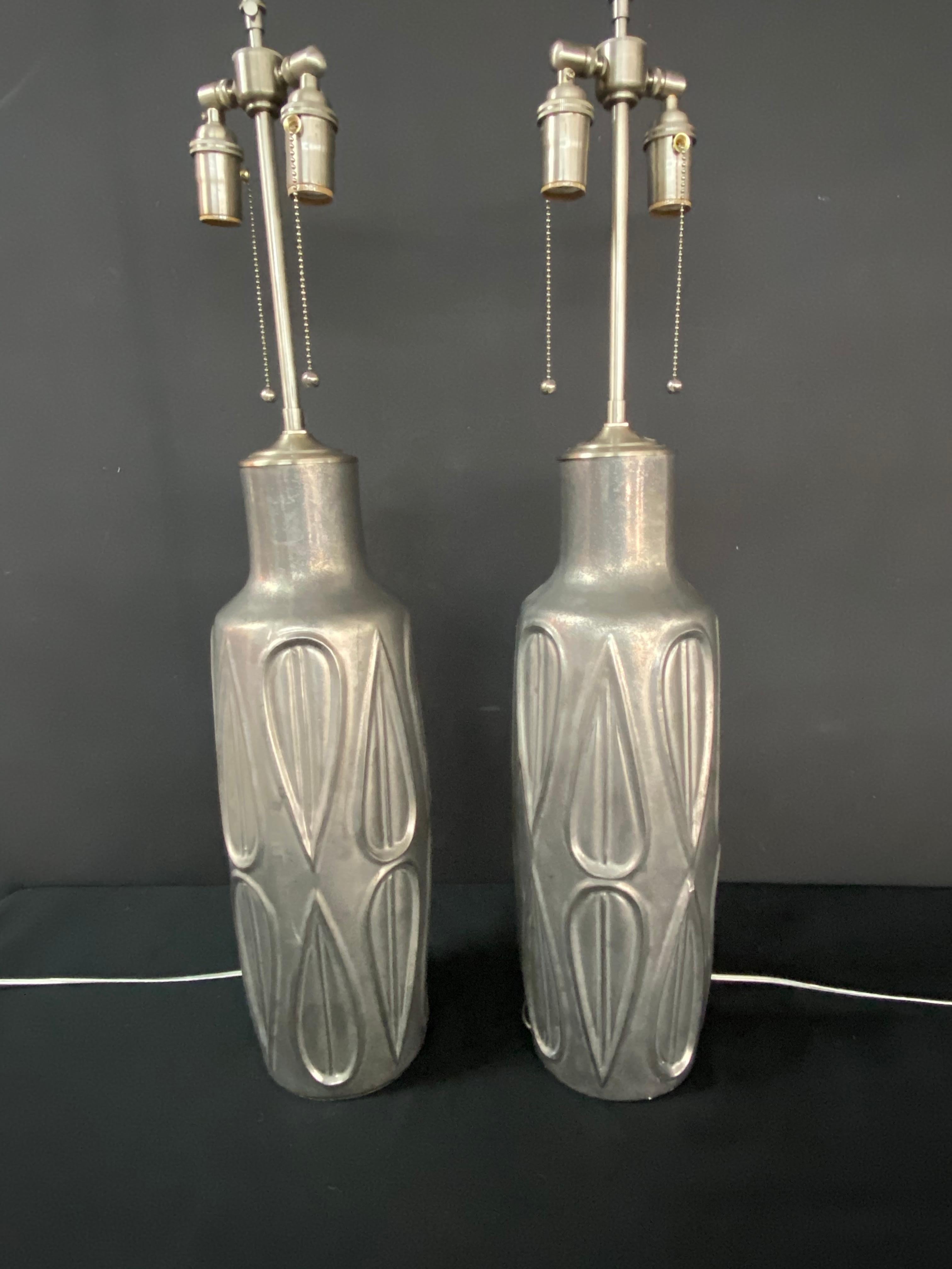 A unique pair of elegant vessels in a soft patina metal finish with lamp application. Our lamps have the unique distinction of being comprised of vases and vessels that we determine will make excellent lamps, then we convert them into lighting. As a