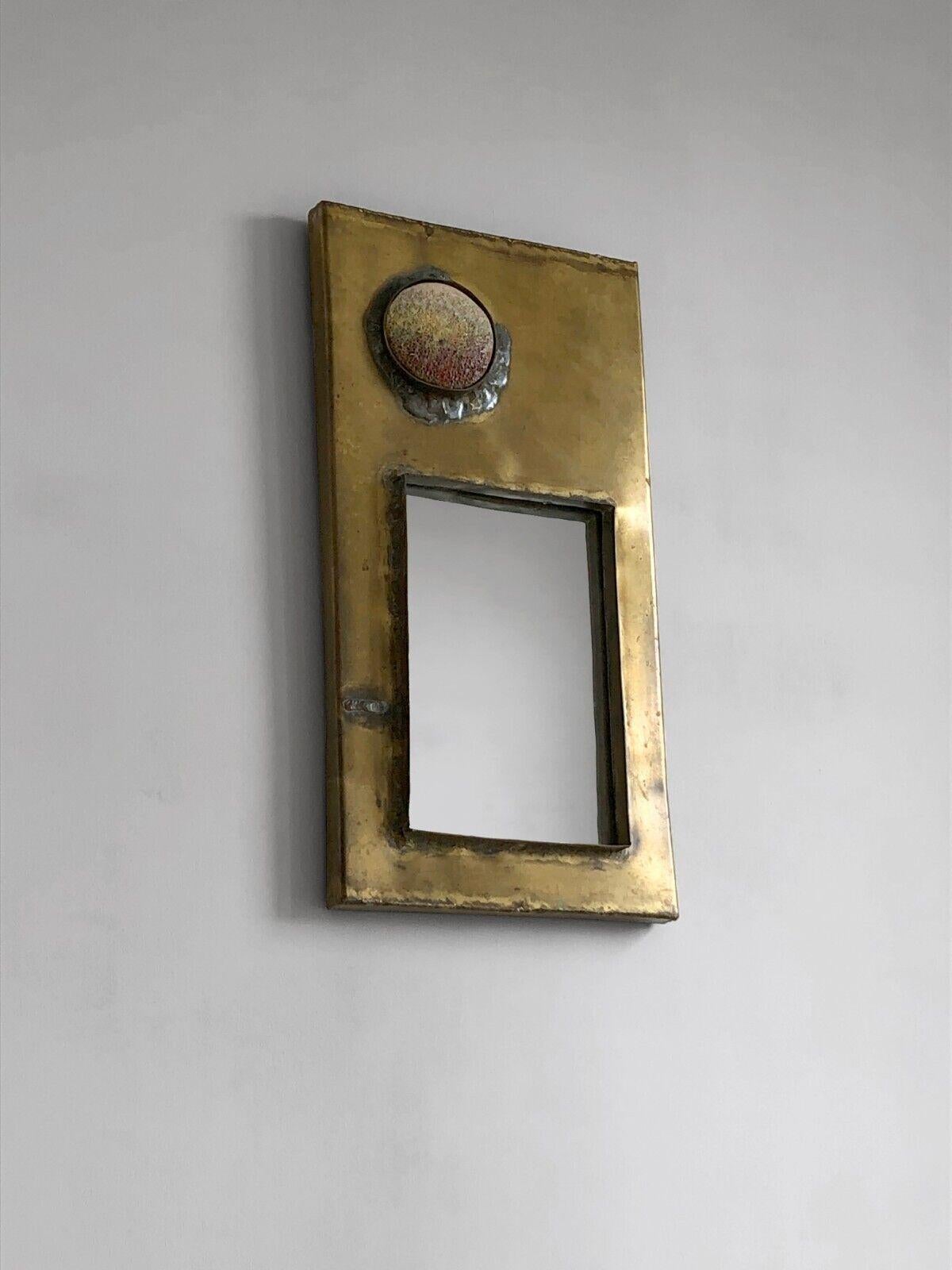An exceptional rectangular and asymmetrical wall-sculpture mirror, Brutalist, large vertical rectangular frame in bronze or patinated brass, with 2 welded asymmetrical inserts arranged in secondary frames:
- at the top left, a half-hemisphere in