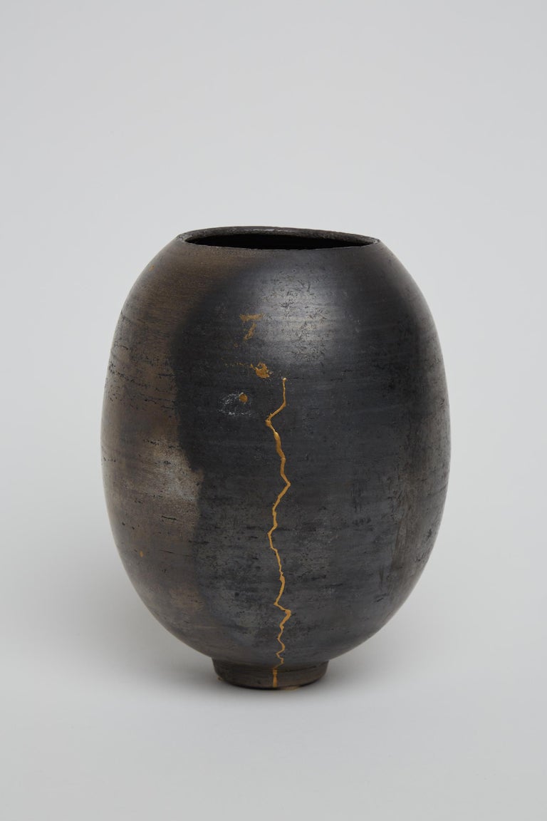 A vase by artist Karen Swami, 2021.
A unique wheel thrown stoneware, smoked, fired, waxed and reworked with Japanese vegetal 'Urushi' lacquer and pure gold, in the Kintsugi technique. 
Pièce unique / one of a kind - Porous and non utilitarian.