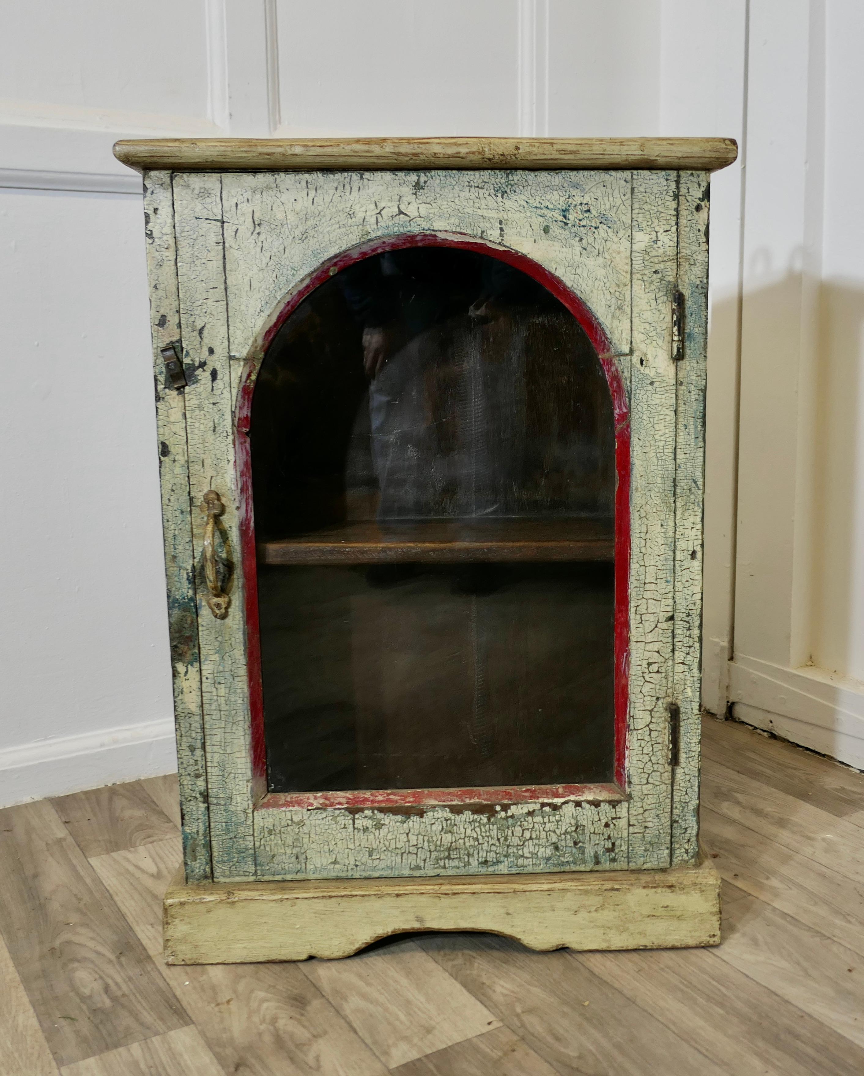 Un utile armadio a muro dipinto in stile shabby  

Un mobile molto utile che può essere appeso alla parete o appoggiato al pavimento, con un pannello di vetro ad arco sull'anta e un utile ripiano all'interno. 
Sarebbe perfetto in una piccola cucina