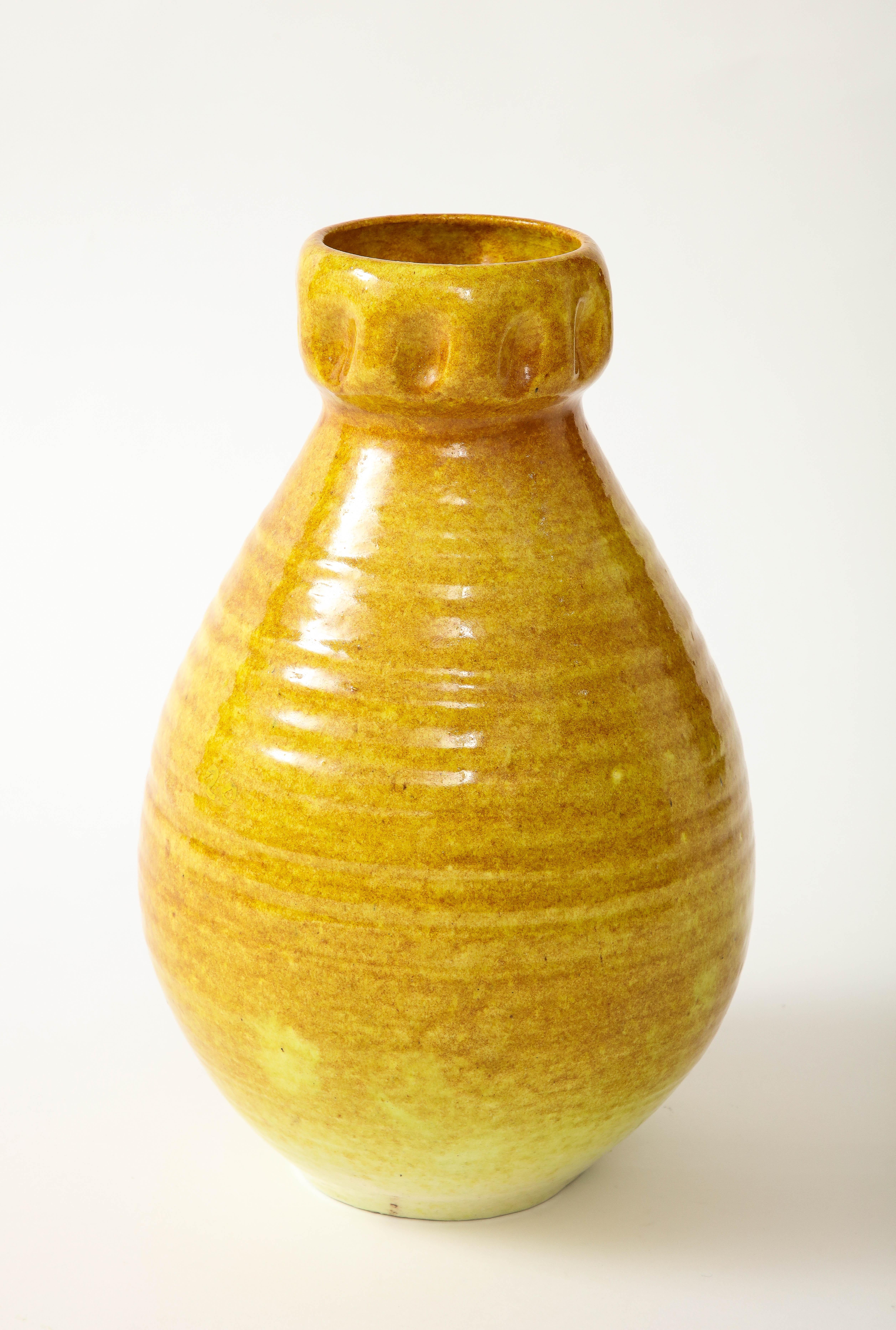 A ceramic vase in a beautiful glaze of a golden yellow produced by Accolay Pottery. Founded in the 1950s in Accolay, France, the Accolay studio became well known after it produced buttons for the collection of Christian Dior. One of several pieces
