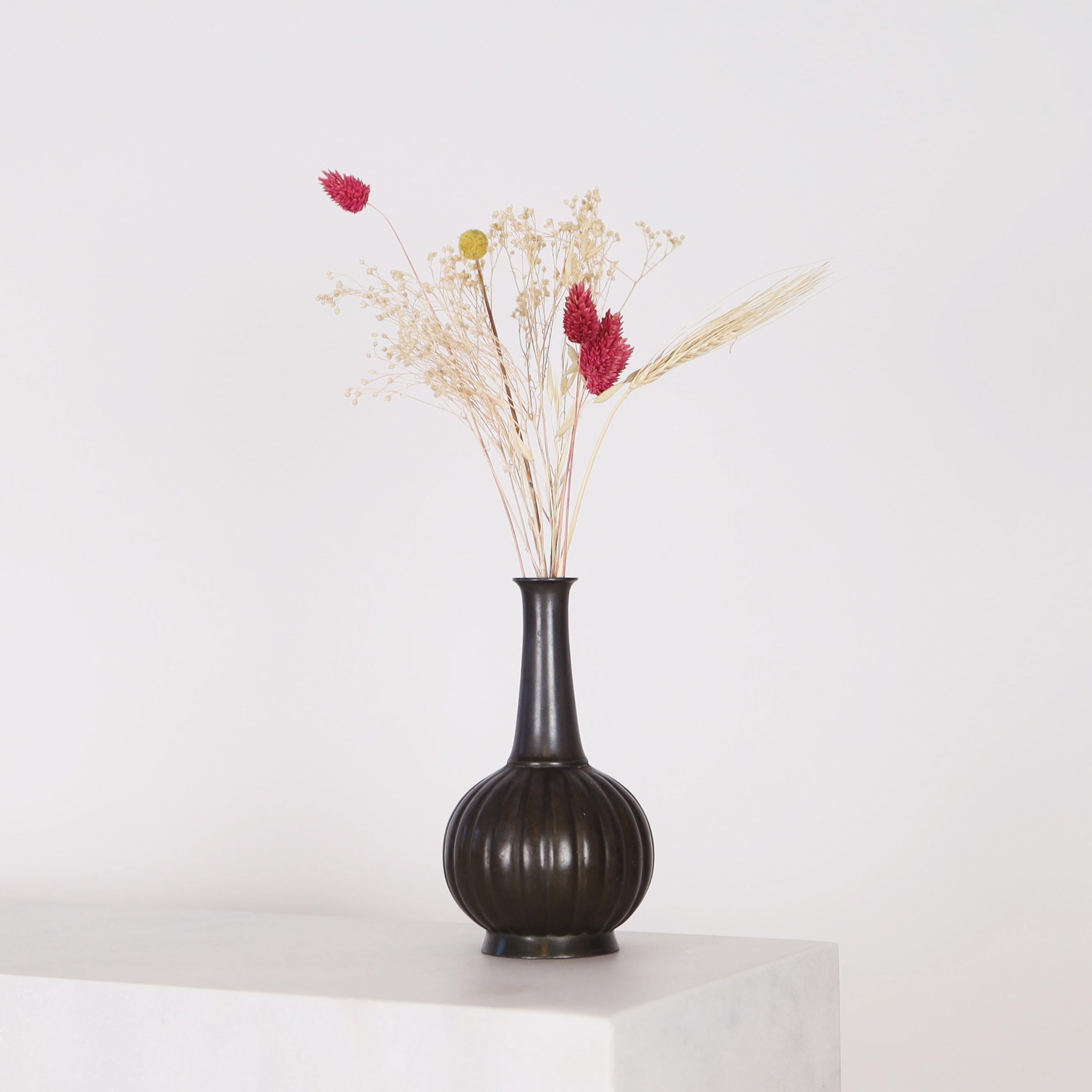 Un vase en métal conçu par Just Andersen dans les années 1920 en bon état vintage. 

* Un vase en métal en forme de bouteille avec des lignes verticales sur la base ronde.
* Designer : Just Andersen
* Modèle : D134 (estampillé 
