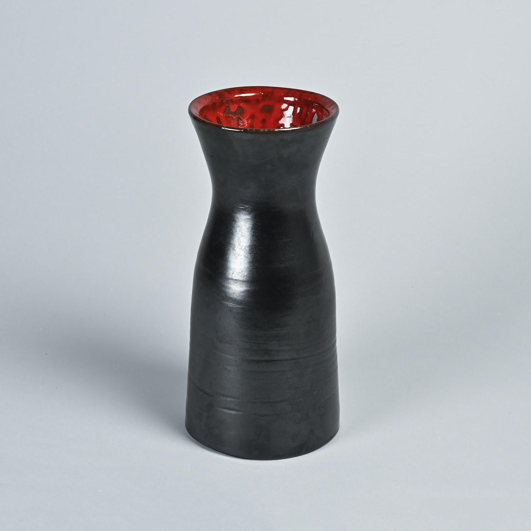 Vaso di Robert and Jean Cloutier, due maestri della ceramica francese famosi per le loro opere vibranti e oniriche.

Questo vaso ha una forma cilindrica con un collo svasato e presenta uno smalto nero opaco all'esterno e il caratteristico smalto