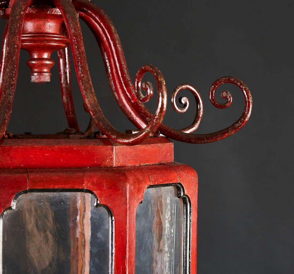 An unusual early twentieth century red Venetian Chinoiserie lantern with scrolling fronds to the top, the original glass panels framed in black cartouches, terminating in a tiered finial, with concentric black rings to each tier.