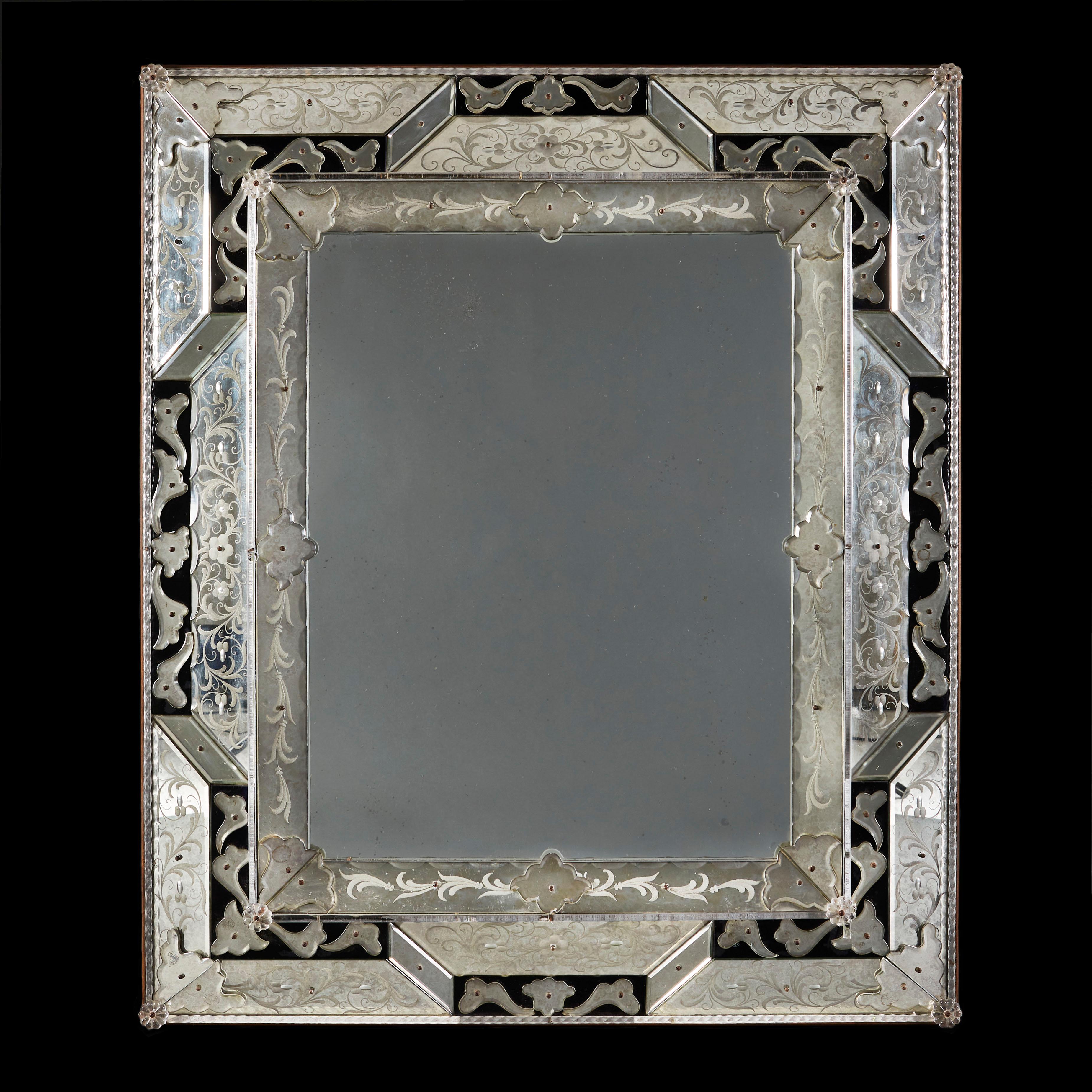 An early twentieth century rectangular Venetian cut glass mirror with panels of black glass and applied cut foliate designs, retaining the original mirror plate.