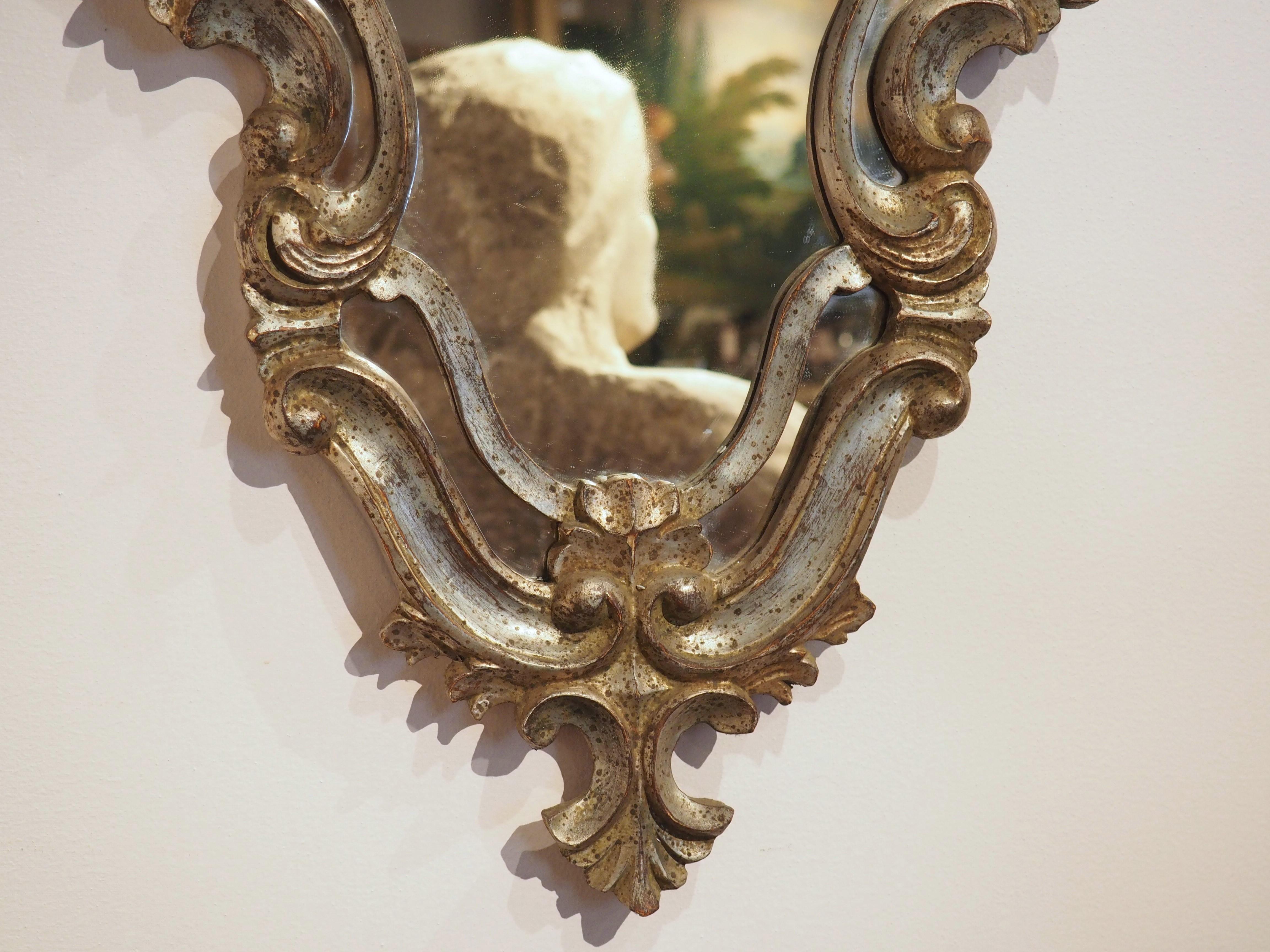 Verleihen Sie Ihrem Zuhause einen Hauch von zeitloser Eleganz mit diesem wunderschönen antiken Spiegel aus Italien. Dieser 32 Zoll hohe Spiegel aus vergoldetem Holz im venezianischen Stil stammt aus den 1920er Jahren und hat eine silberne und