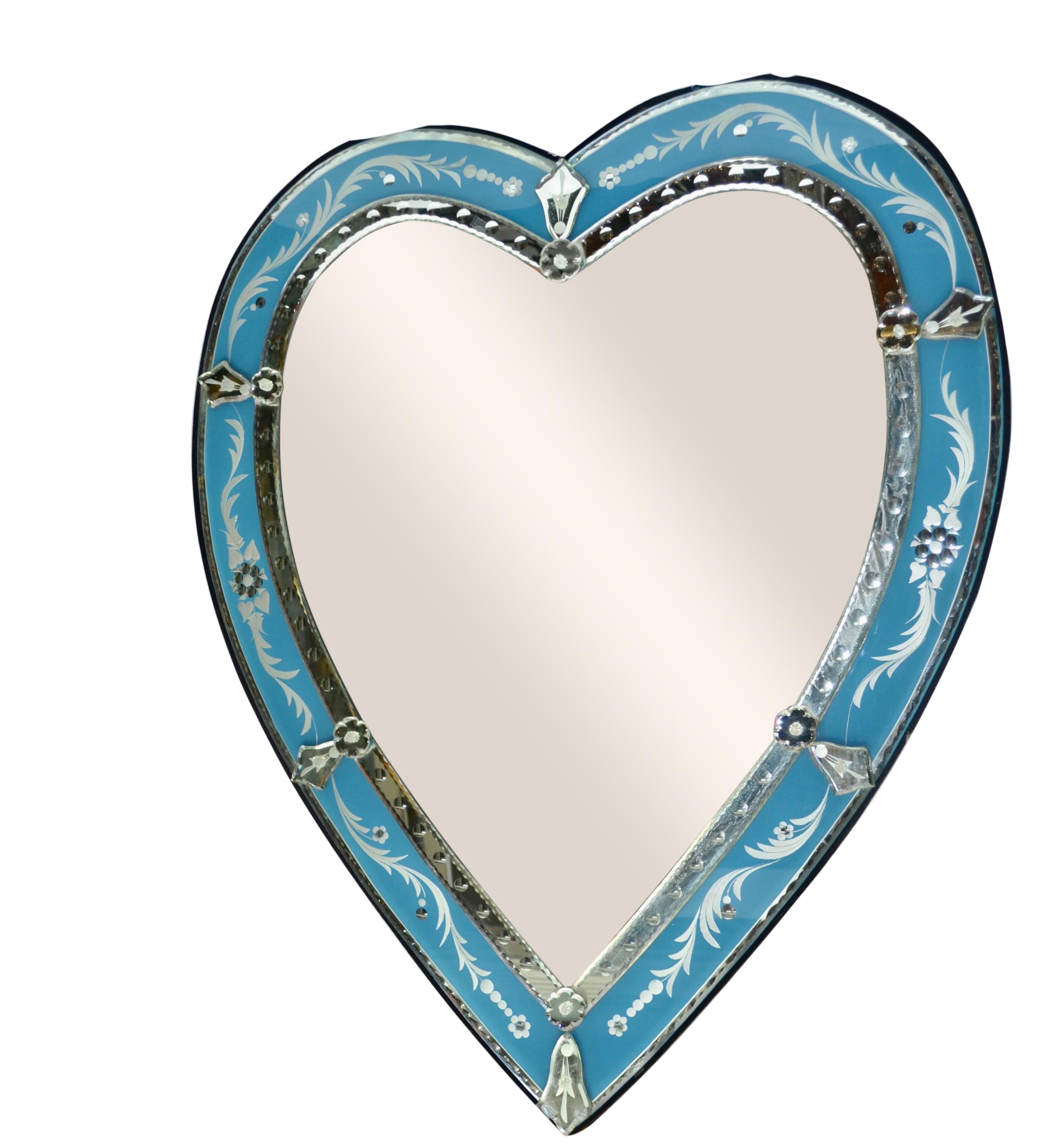 A decorative heart shaped Venetian murano glass mirror with an light blue glass border.