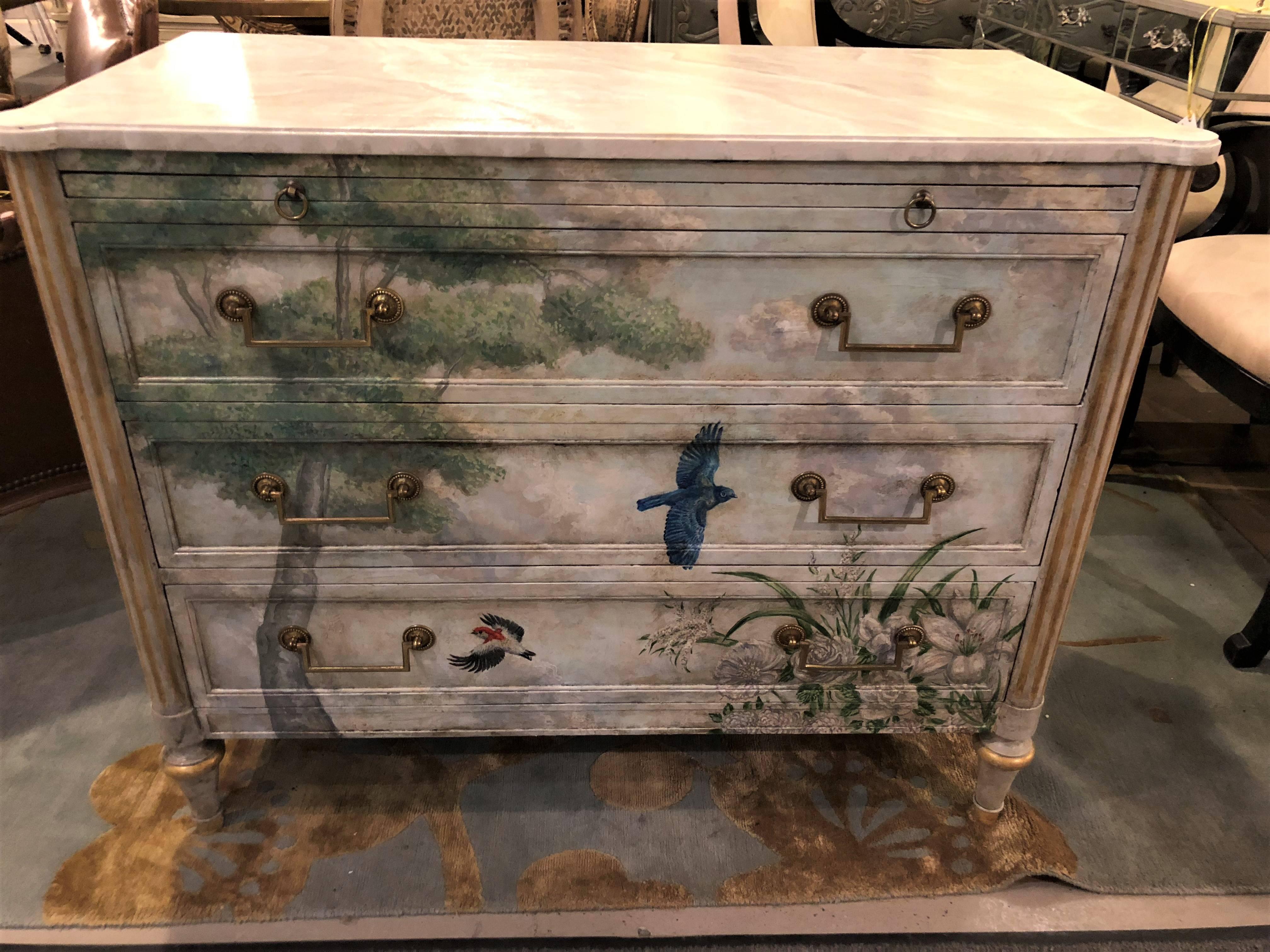A Venetian paint decorated and parcel-gilt gold commode or bed stand in the manner of Maison Jansen. A wonderful paint decorated commode having a faux white, grey and beige marble top. The case in the Louis XVI style having three drawers and a