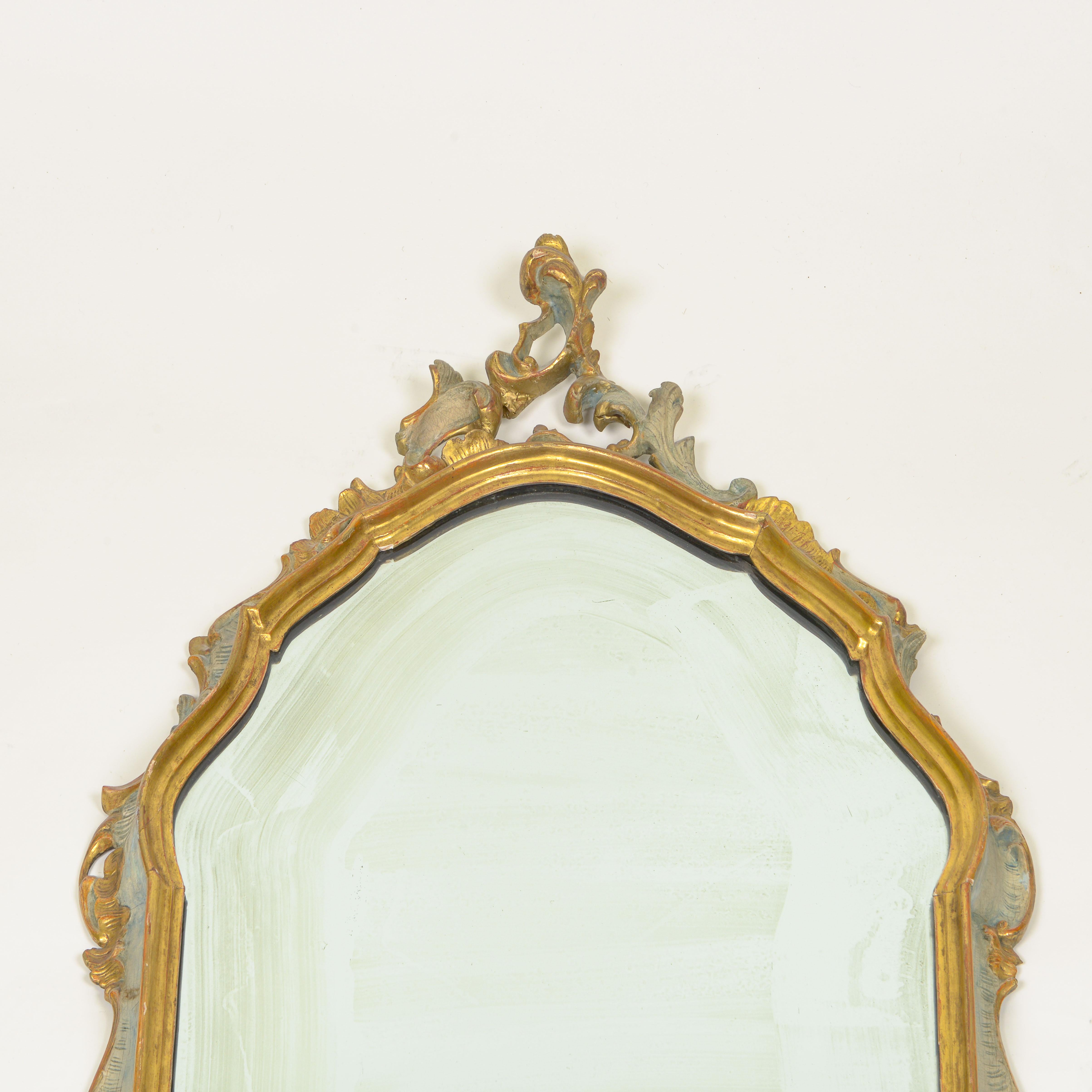 La plaque de miroir, de forme cartouche, est entourée d'un cadre conforme sculpté d'un décor de rocaille.