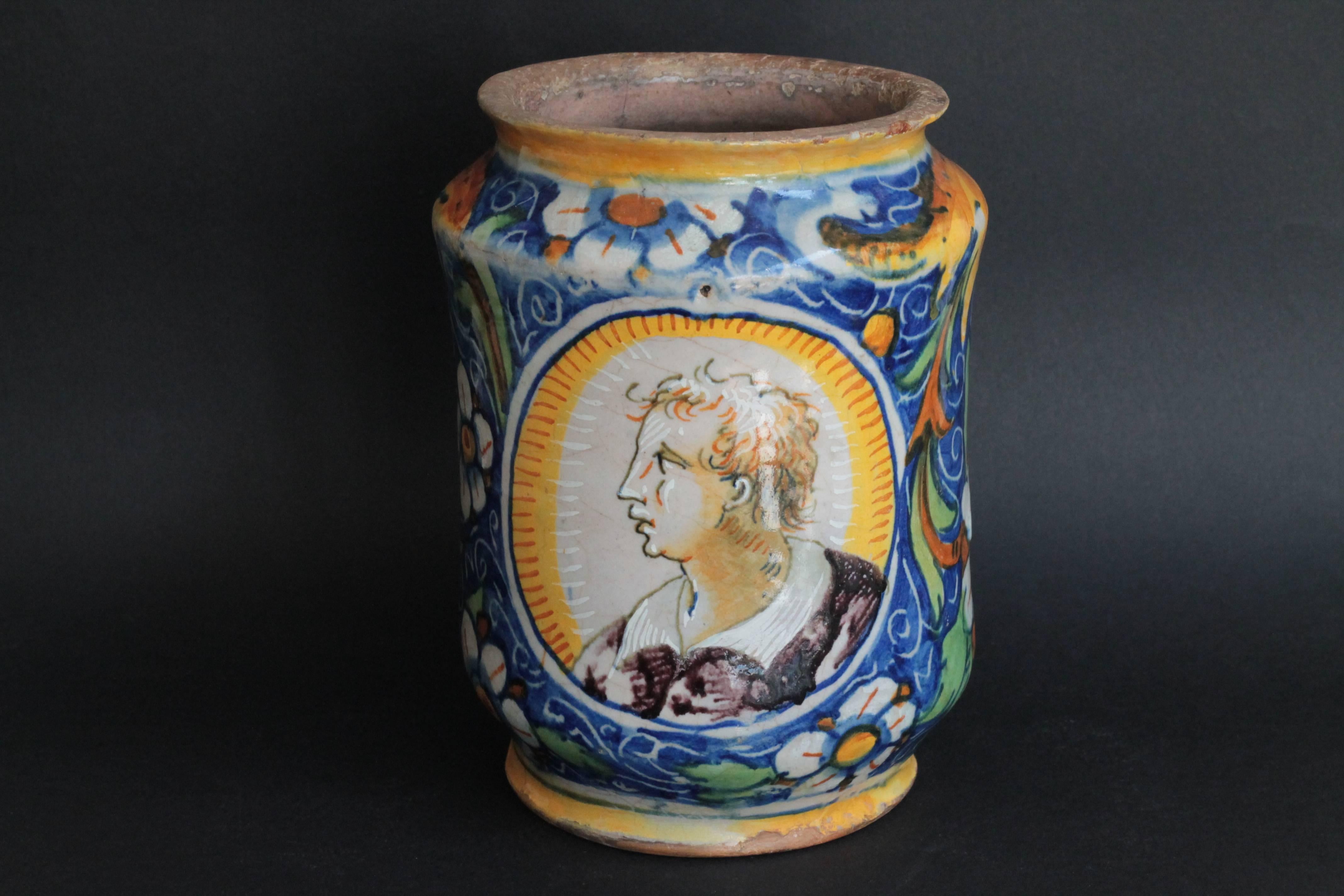 A Venice (Italy) Maiolica Albarello with polychrome decoration with a continuous dense floral and fruits on a blue ground and two portraits of young man of profile. 
Workshop of Maestro Domenico, circa 1570-1580. End of the 16th century.