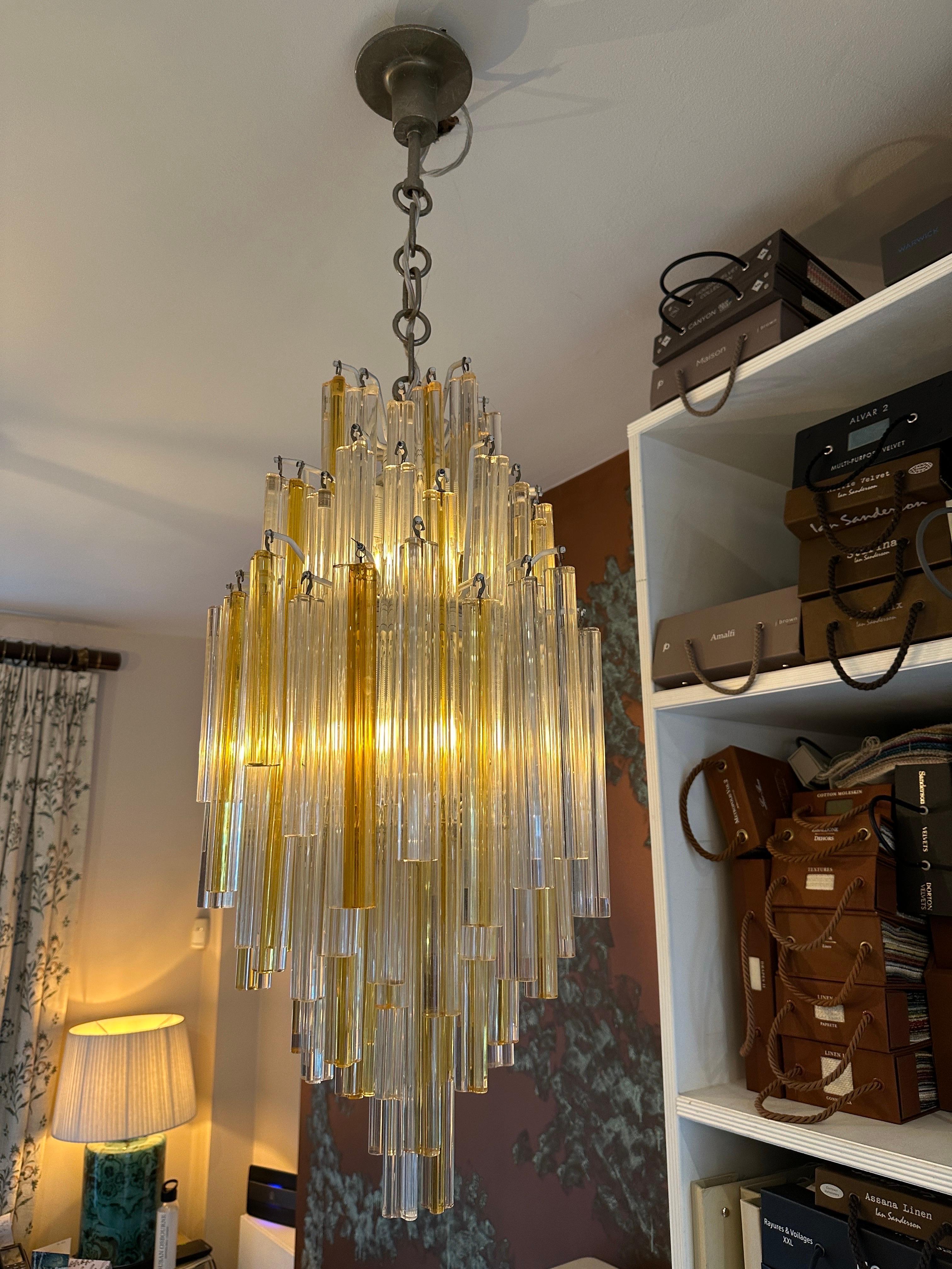 An Italian Murano glass pendant with clear and gold infused Murano Glass Trilobo pieces. Hung from a white lacquered frame and the frame staggered so the pieces are at different un uniformed levels. An original piece circa 1960 with original chain