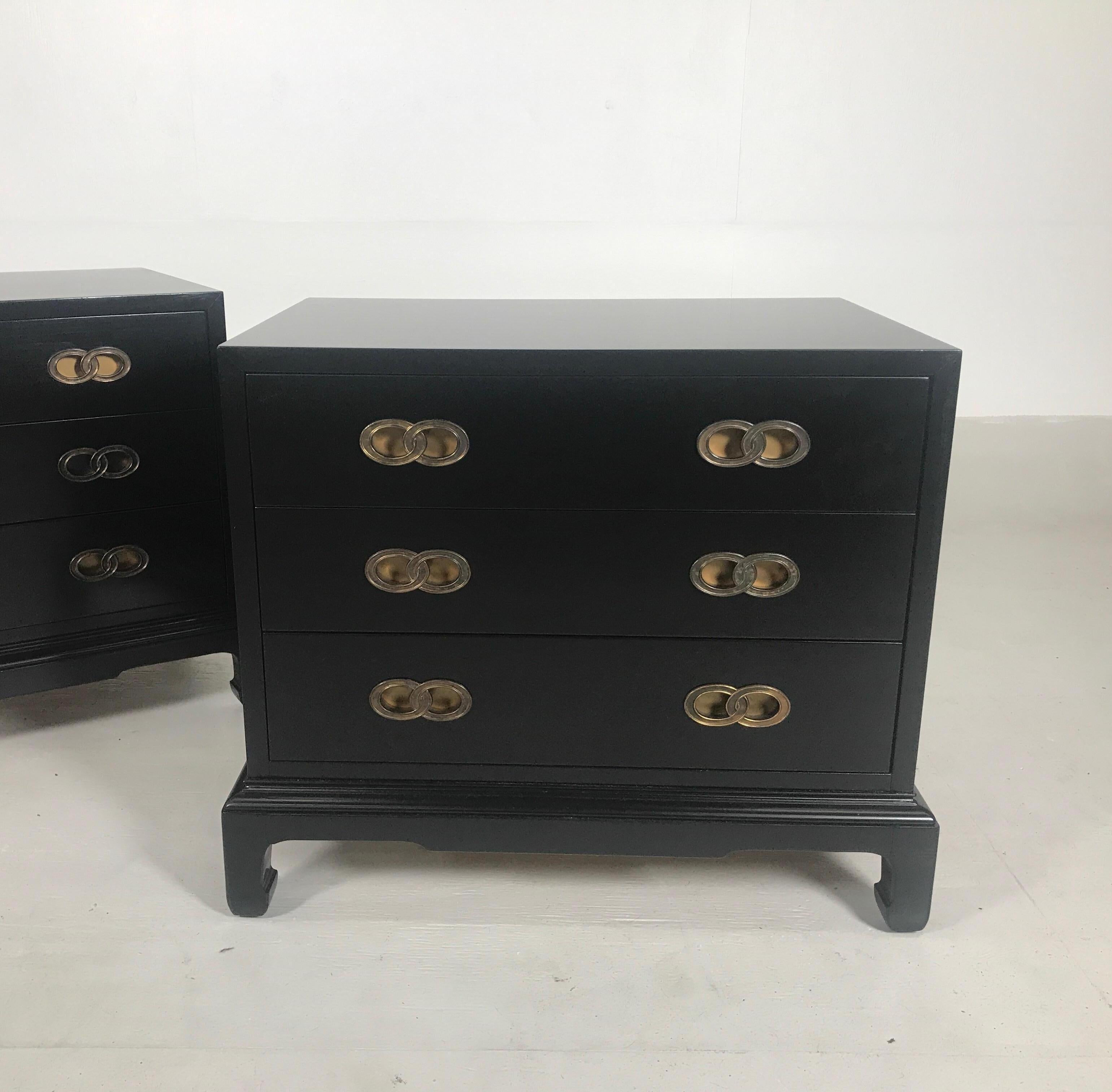 A pair of black three-drawer chests by Henredon, 1960s. The ebonized finish over solid wood with beautiful recessed double ring knot style handles. The square chests with Asian inspired James Mont style bases.