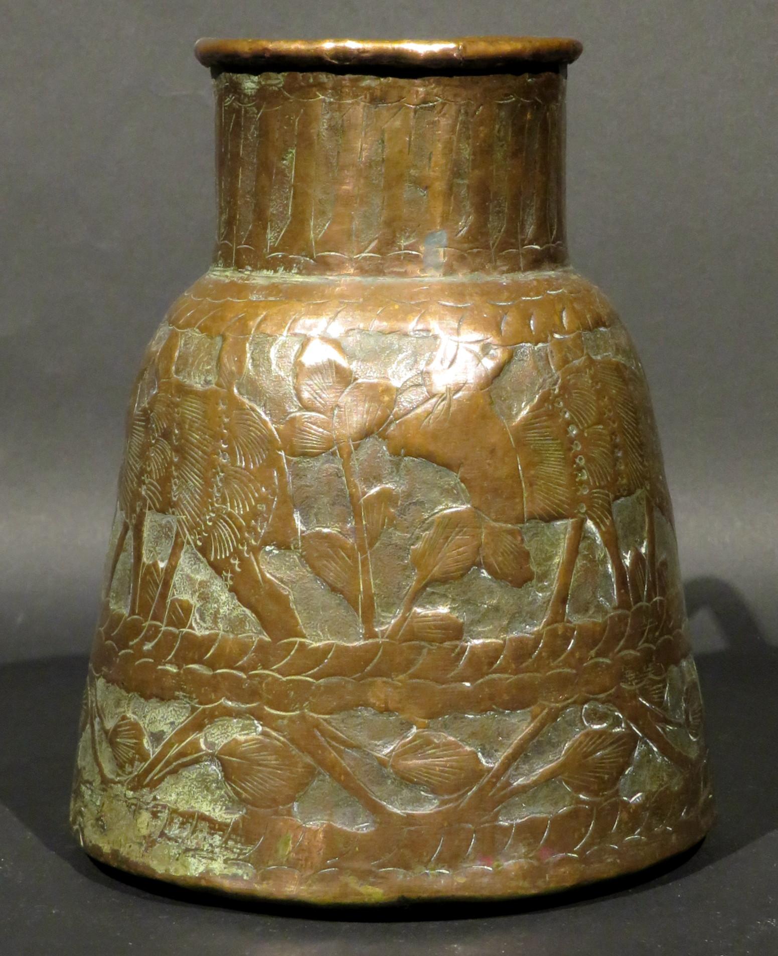 The conical shaped body rising to a collared neck and affixed with an applied brass handle, the exterior decorated overall with embossed motifs of deer, peacocks & foliage, the underside showing an old dovetail seamed construction.
