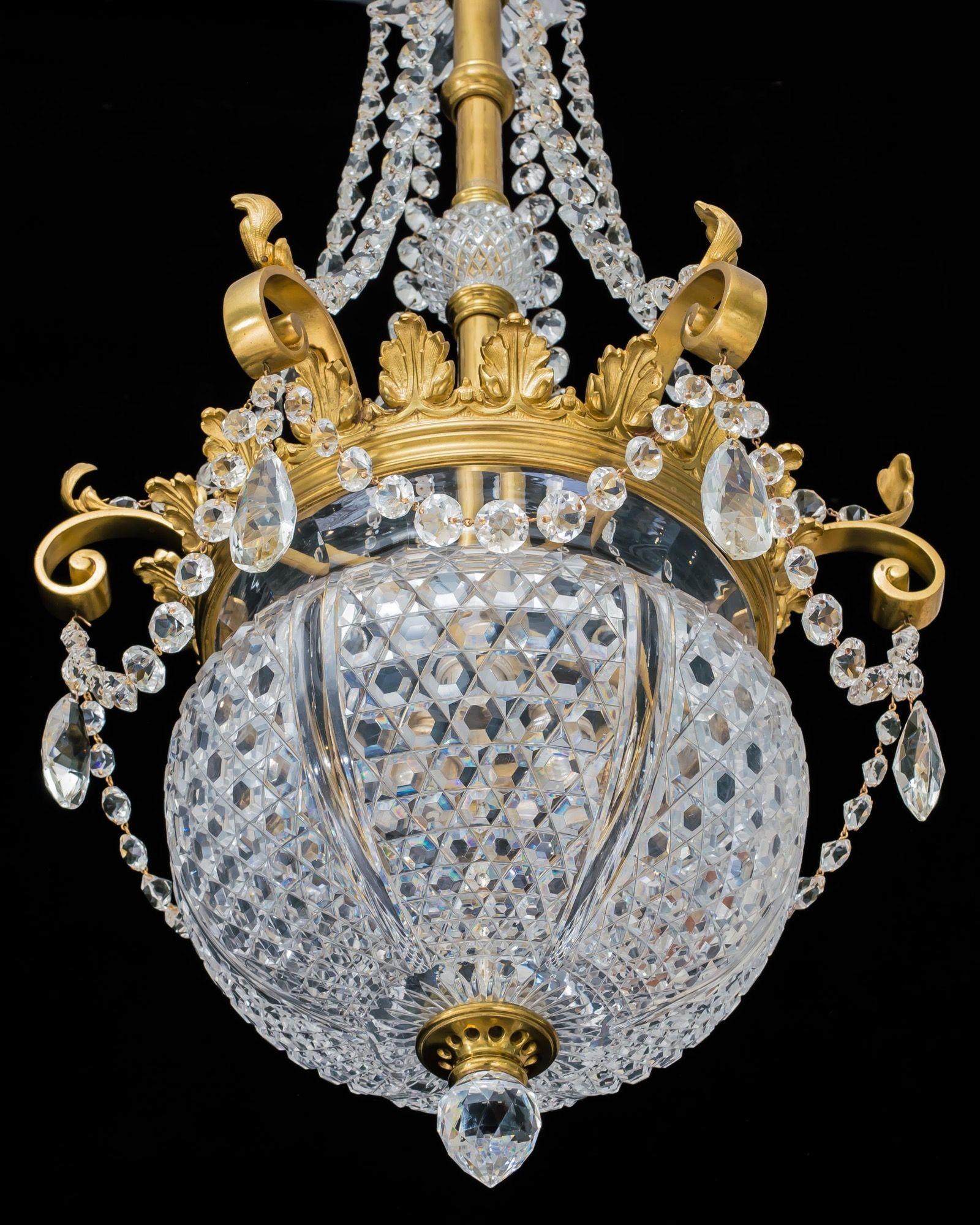 An elaborate ormolu and glass lantern by F&C Osler, with hexagonal cut panelled bowl mounted in an ormolu ring, decorated with leaf atheneums and swaged with glass spangles. A central rod, with central cut glass ball, leading to top canopy, hung