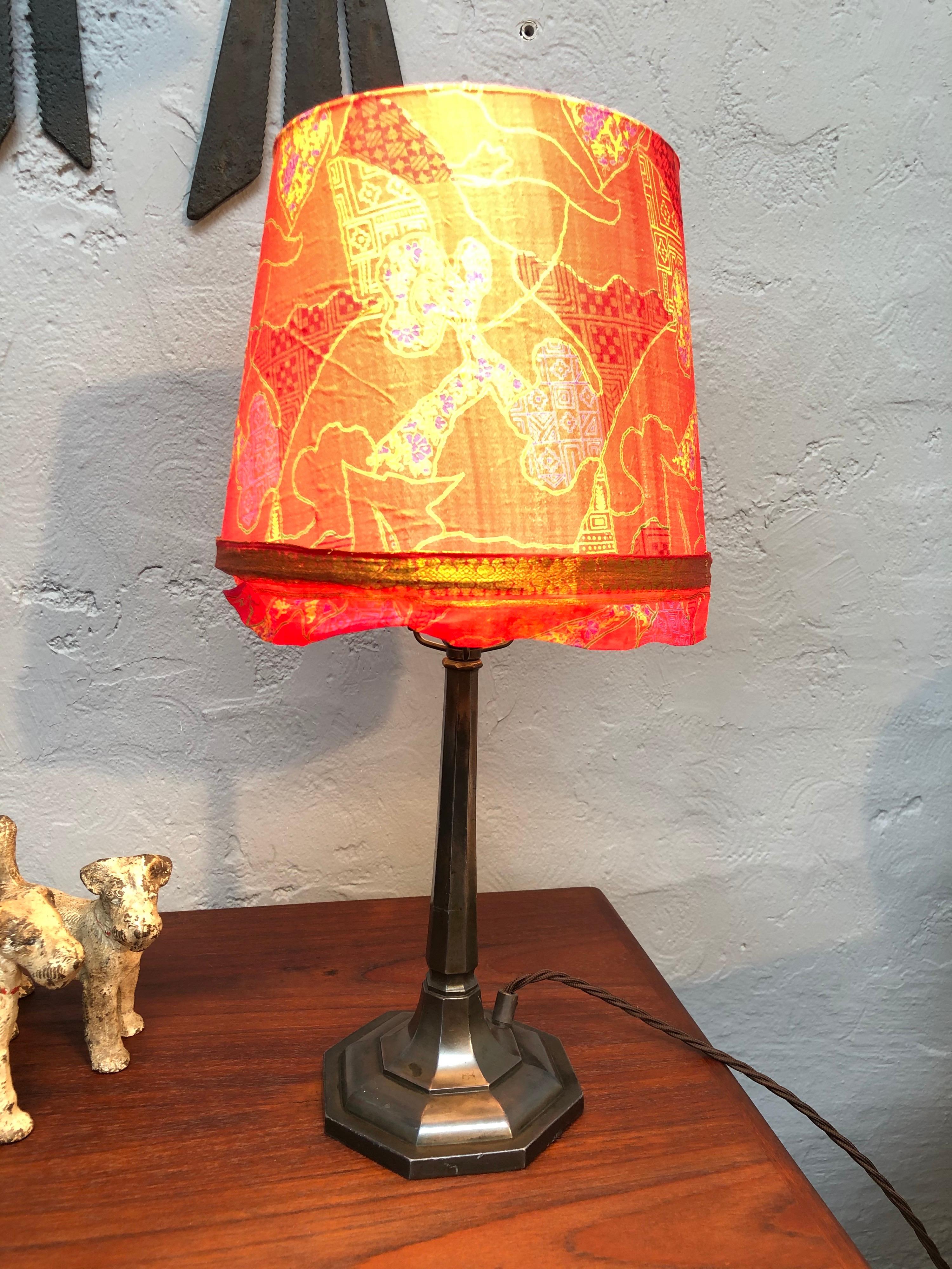 A very elegant antique Art Deco cast alloy table lamp. 
Maintaining its original Bakelite bulb holder and also its original brass lamp shade holder. 
Lamp has been rewired and grounded with a brown twisted cloth cable. 
Lamp shade not included.