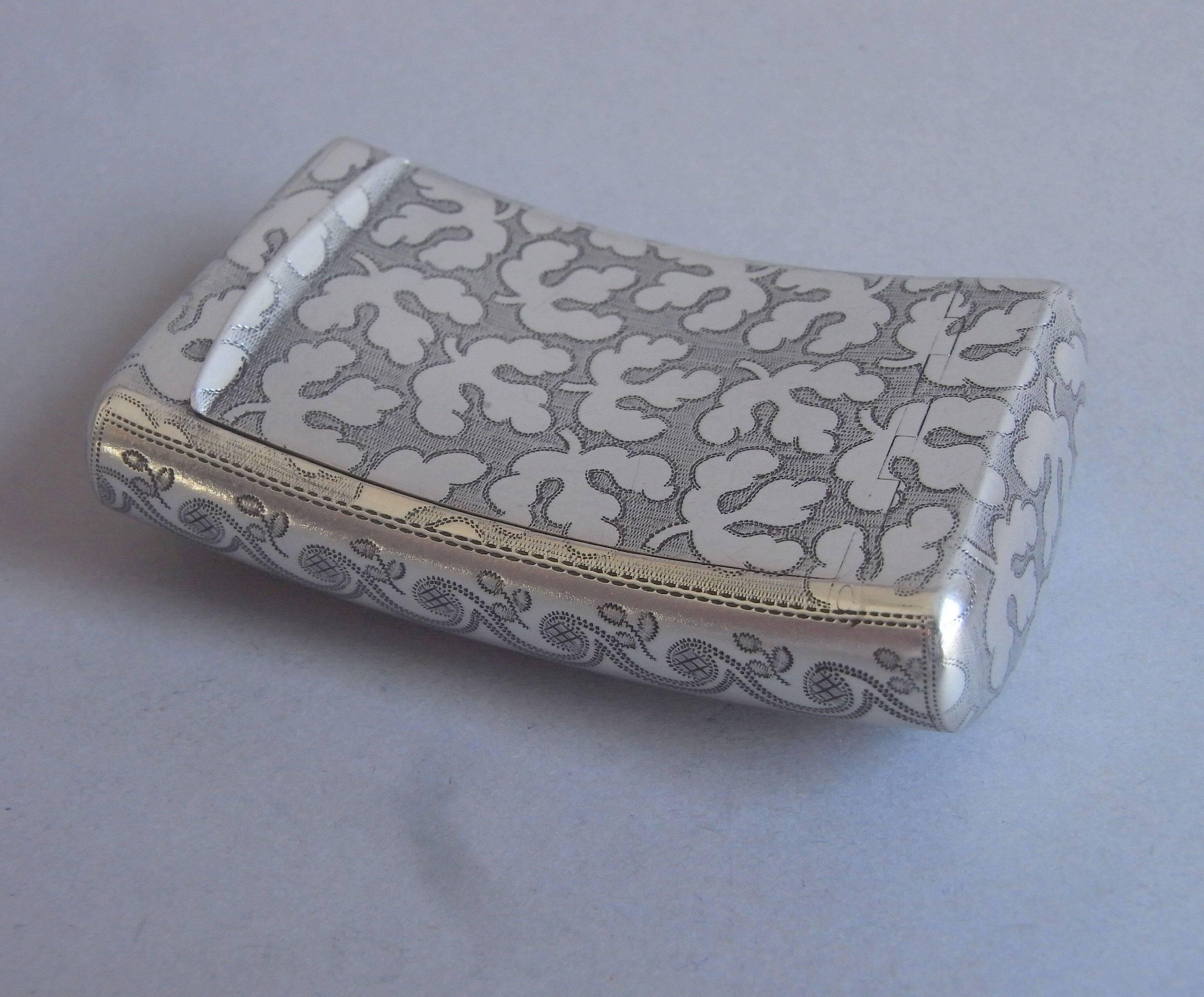 The pocket snuff box is of an unusually large curved form and is decorated on the hinged cover, base and two sides with unusual stylized sycamore leaves on a prick dot ground. The sides are engraved with a band of prick dot waves with foliate sprigs